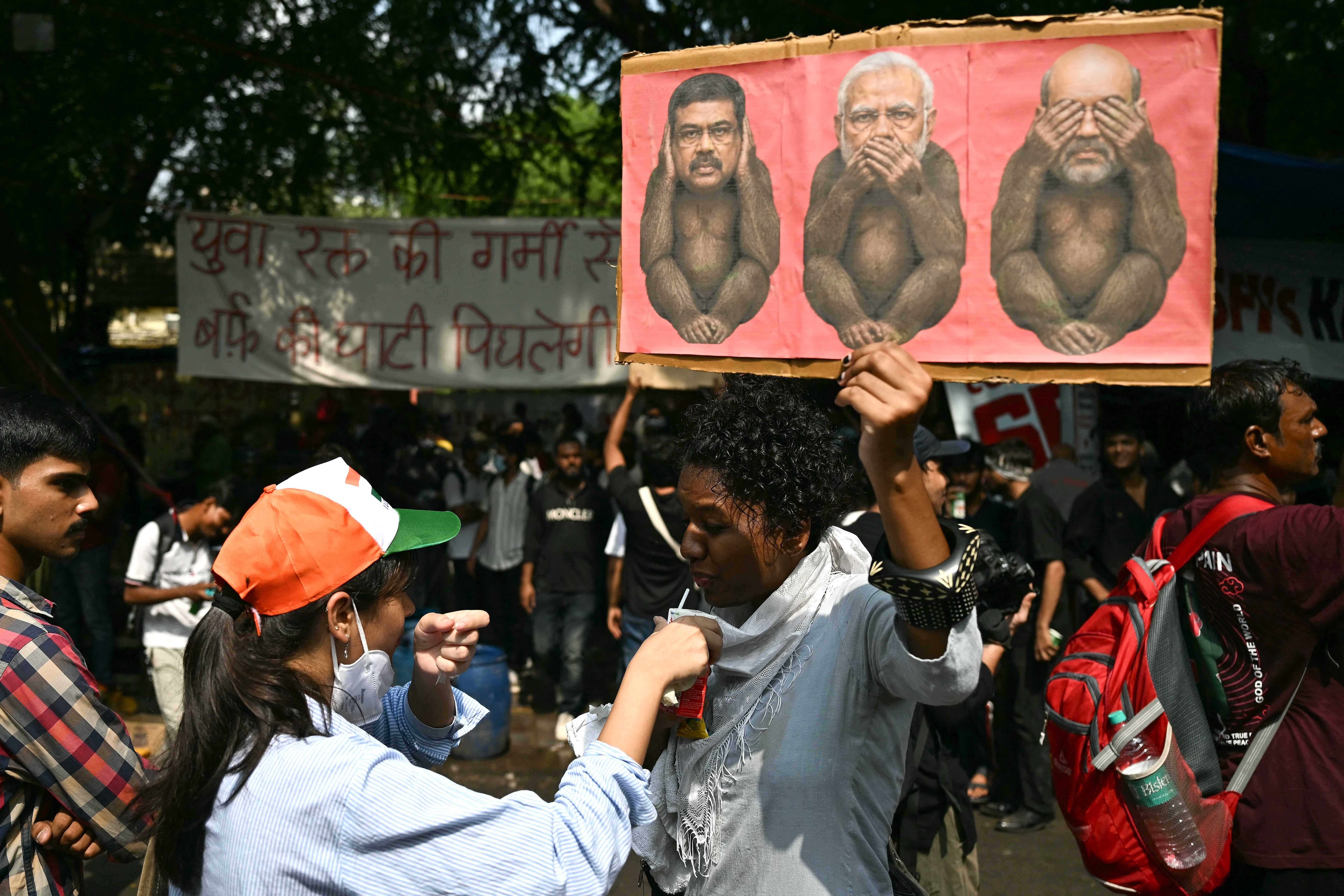 A Cockroach Janta Party (CJP) supporter holds a placard as she drinks ORS (AFP/Getty)