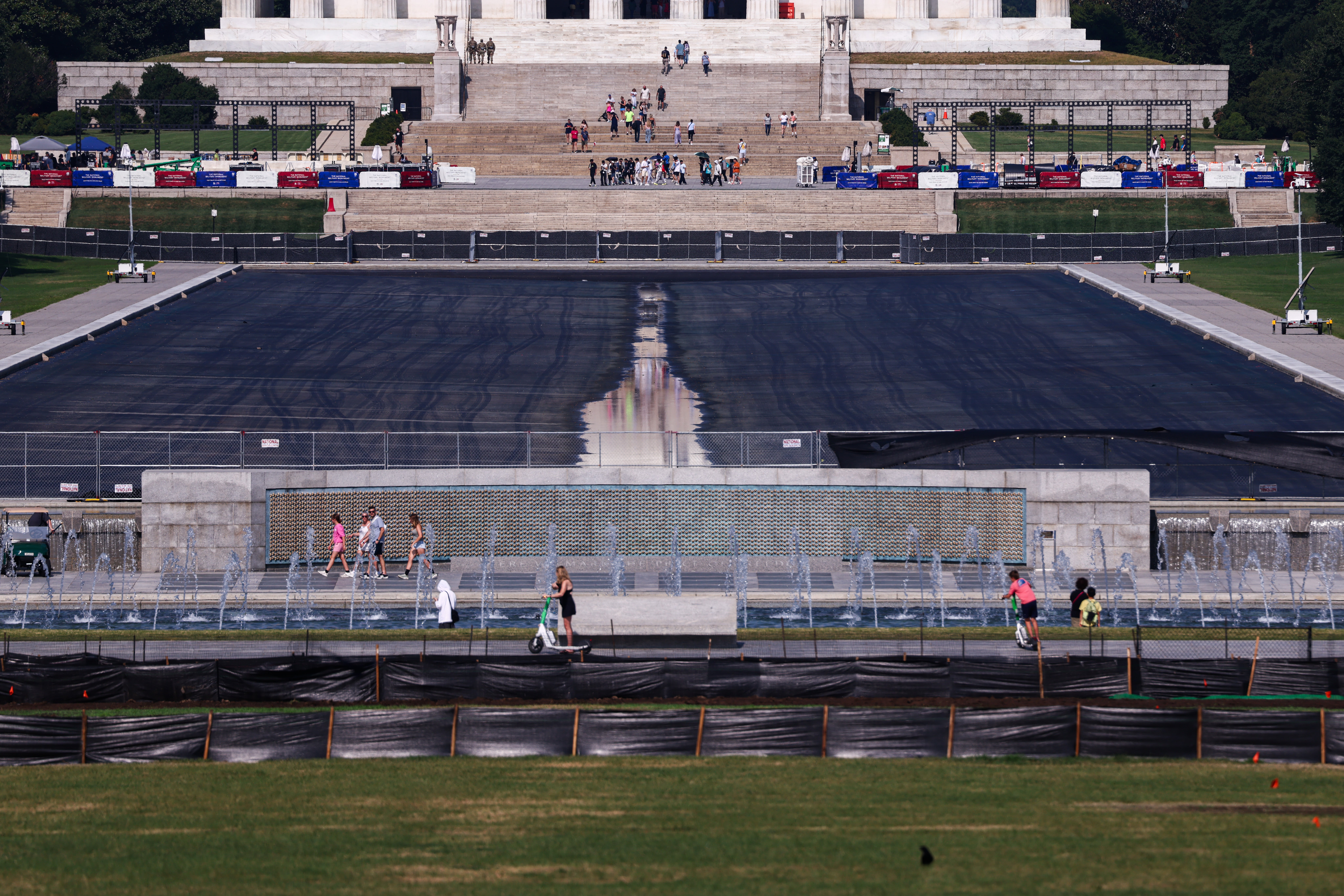 People walk past the drained Reflecting Pool on the National Mall on July 22, 2026 in Washington, DC.