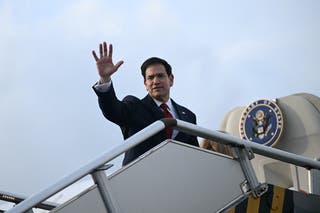 US Secretary of State Marco Rubio waves from the top of the steps to his plane as he departs at Ninoy Aquino International Airport in Metro Manila