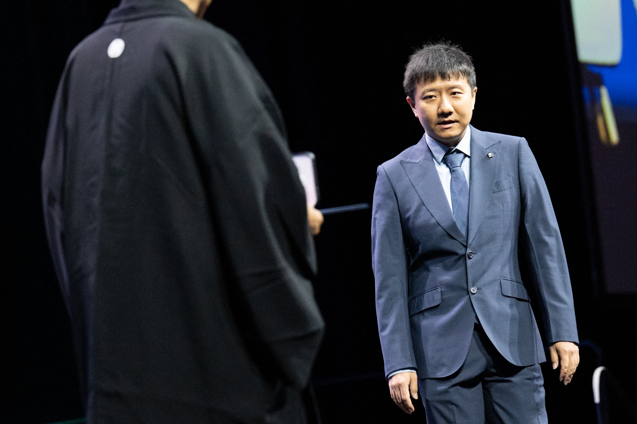 Chinese mathematician Yu Deng walks onstage as he is awarded the 2026 Fields Medal during the International Congress of Mathematicians in Philadelphia