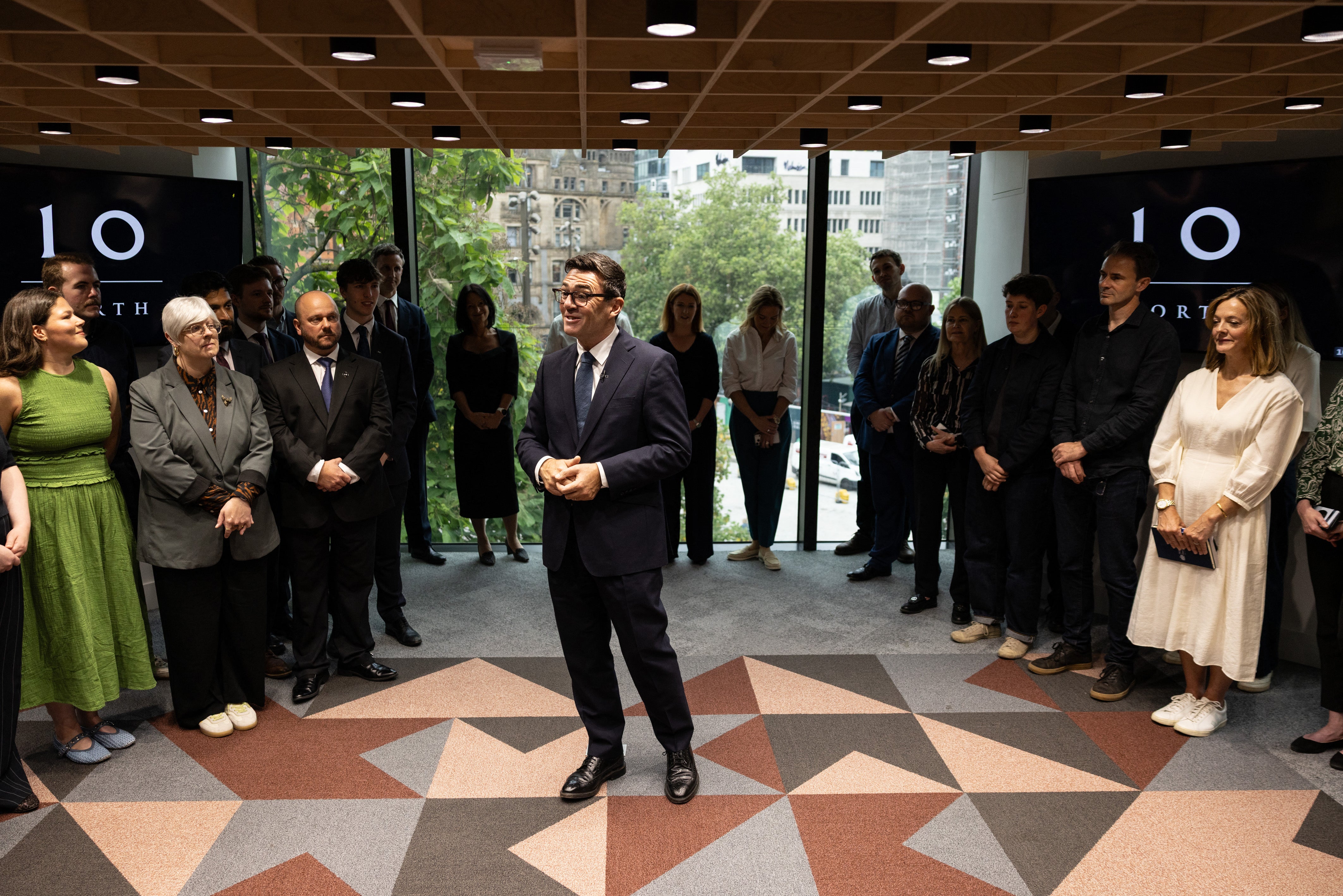 Britain's Prime Minister Andy Burnham speaks to staff members during a visit to officially open No10 North in Manchester