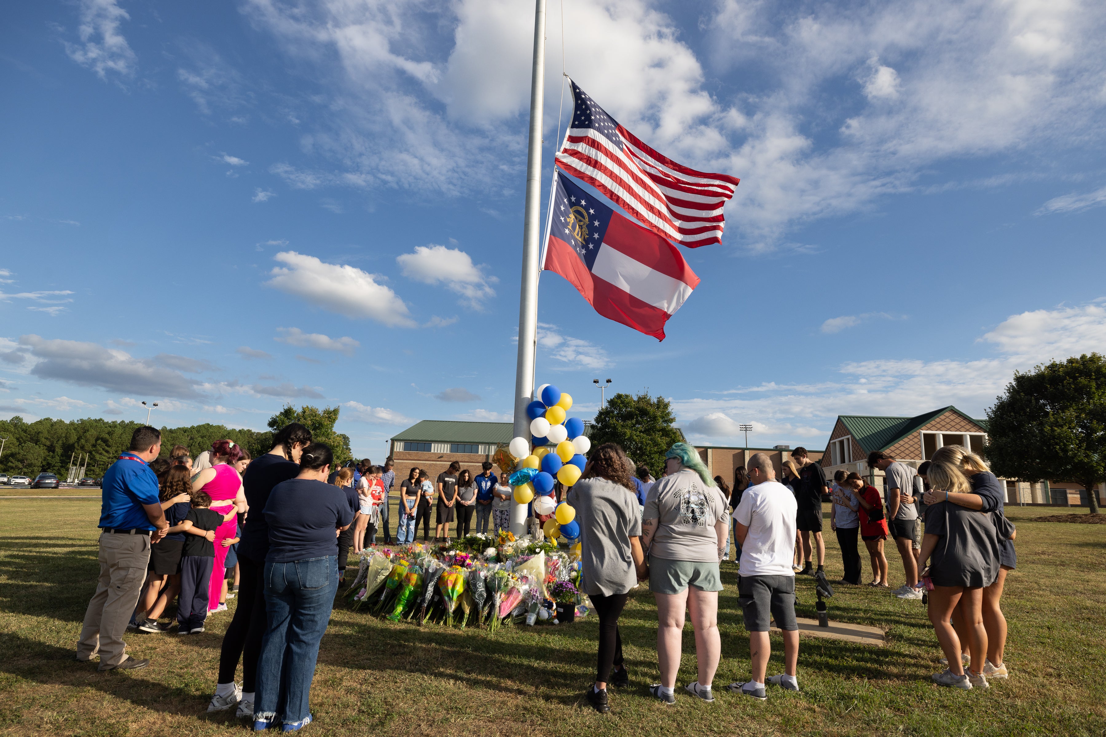 Students and community members make a prayer circle around a makeshift memorial outside of Apalachee High School on September 5, 2024 in Winder, Georgia