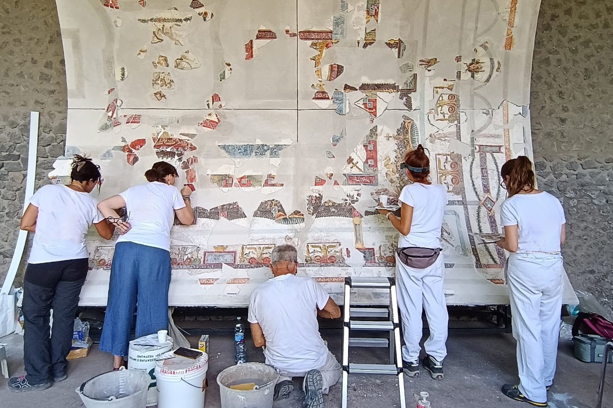 Experts work on part of the restored ceiling vault of the Bakery House