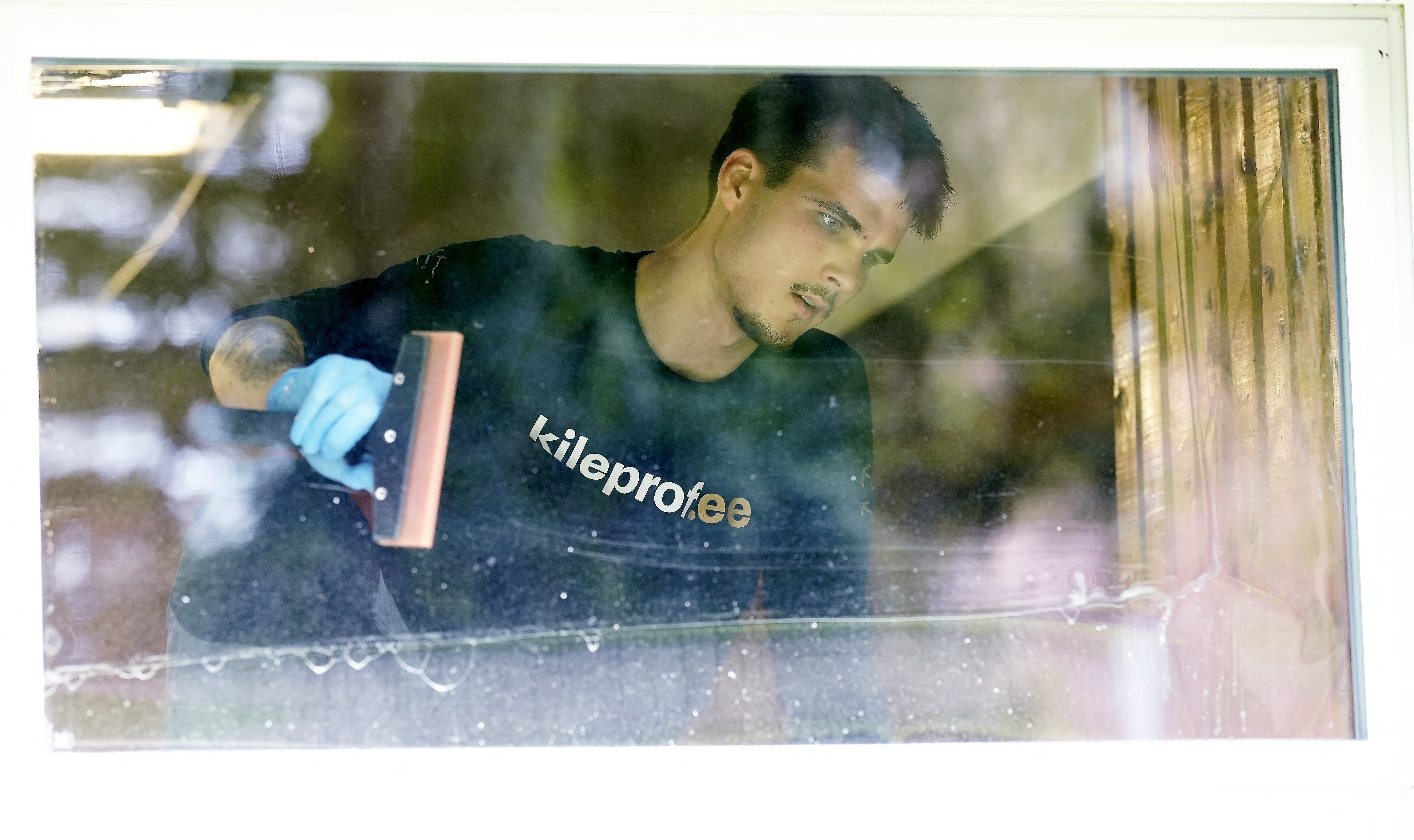 Rasmus Maivel installs plastic film to protect a window of an emergency shelter at Kivilinna school, as Estonian schools reinforce windows to protect against attacks, in Tartu, Estonia July 23, 2026. REUTERS/Ints Kalnins
