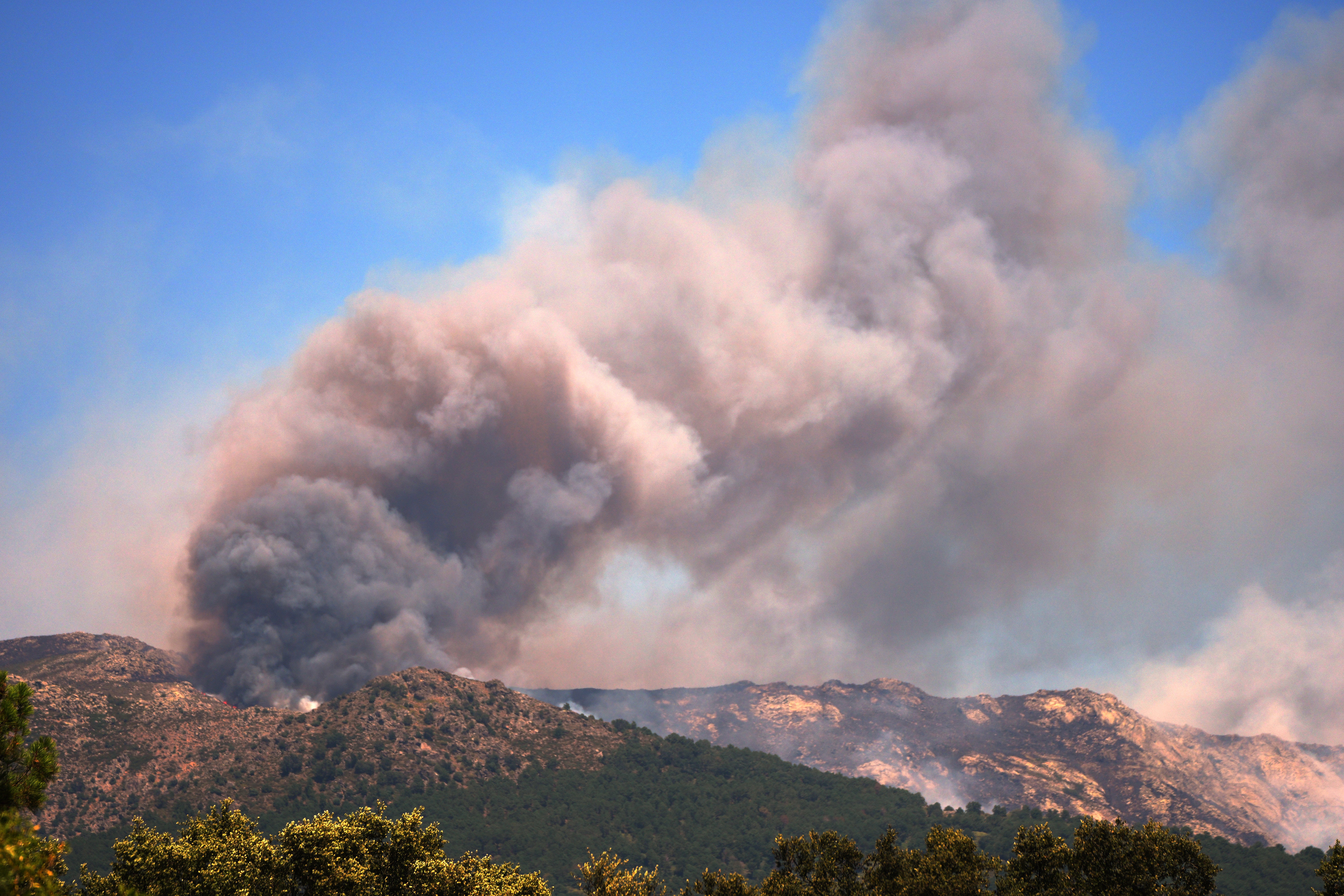 Smoke and flames rise as a wildfire advances near La Adrada, Ávila province, Spain.
