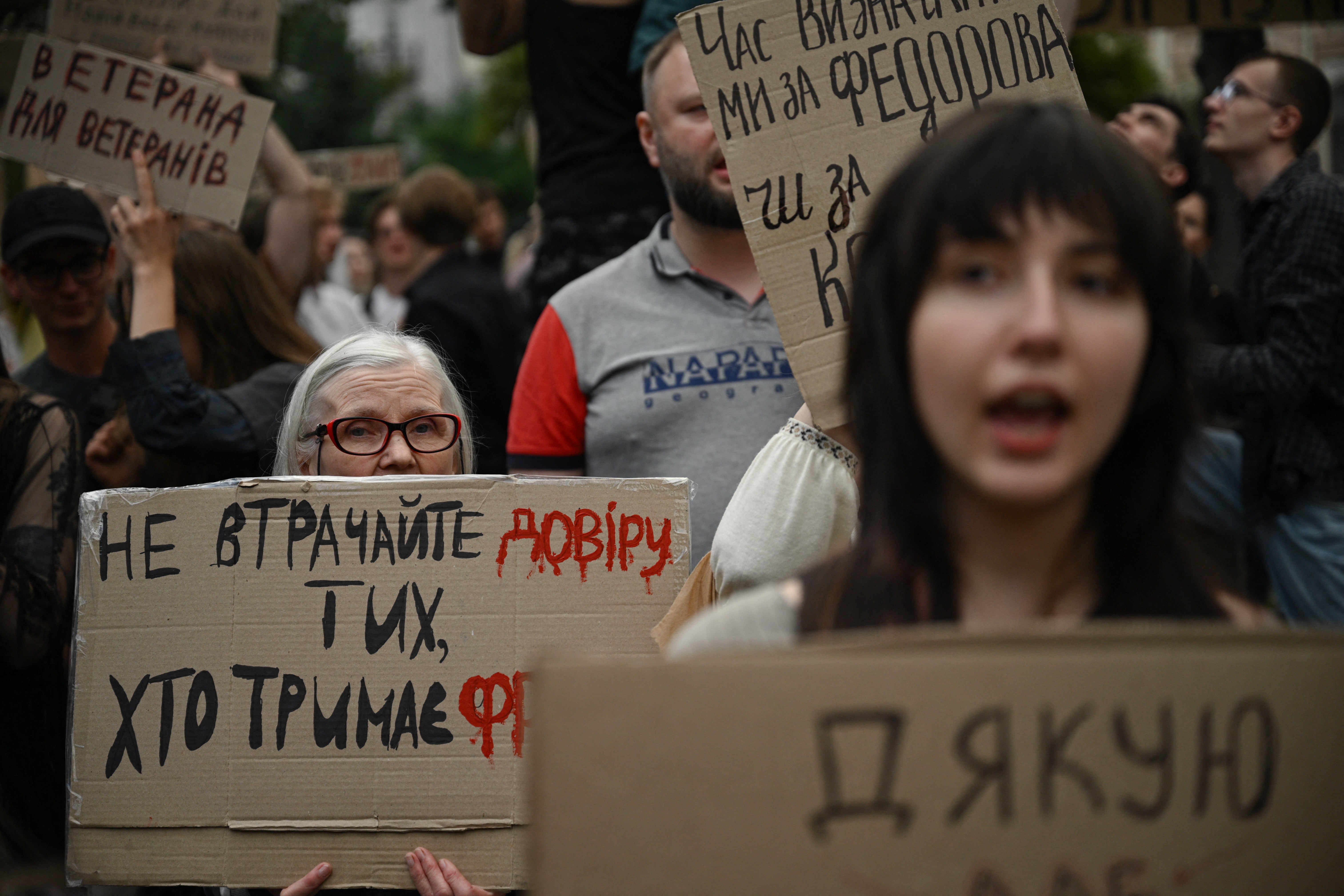 Attendees hold placards and chant slogans during a demonstration to protest against Ukraine's President's decision to dismiss Ukraine's former Defence Minister, in Kyiv on 24 July 2026