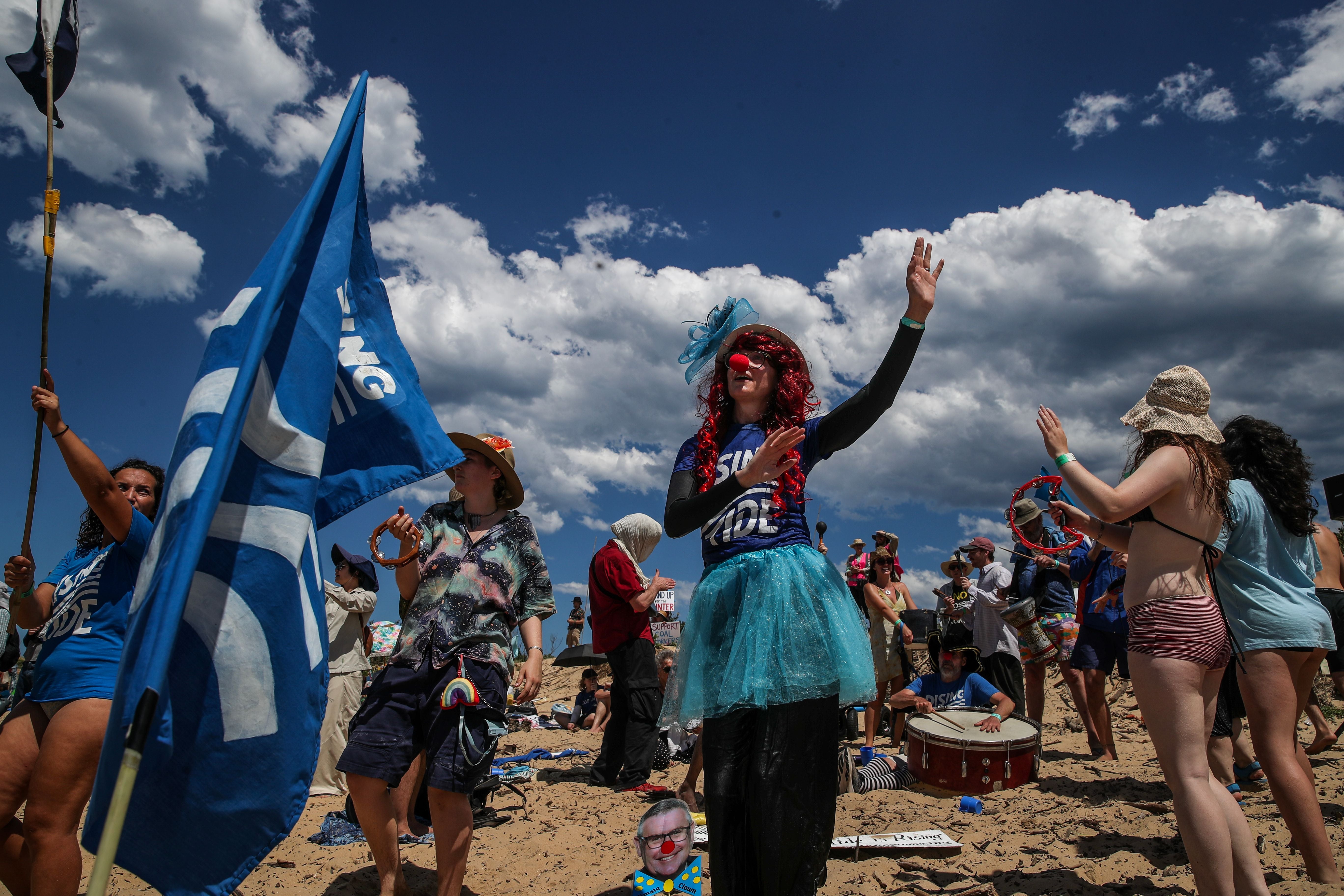Climate protestors dance as they continue their attempt to disrupt the access to Newcastle coal port in protest for climate action at Horseshoe Beach on 30 November 2025 in Newcastle, Australia (Getty)