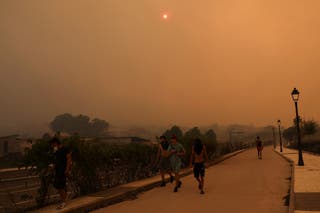 Members of the Kiat Yack Martial Arts Academy of Spanish, Moroccan, Colombian and Romanian origin move to help extinguish flames around the academy in the village of El Tiemblo, during wildfires affecting Castilla y Leon province, Spain, July 24, 2026.