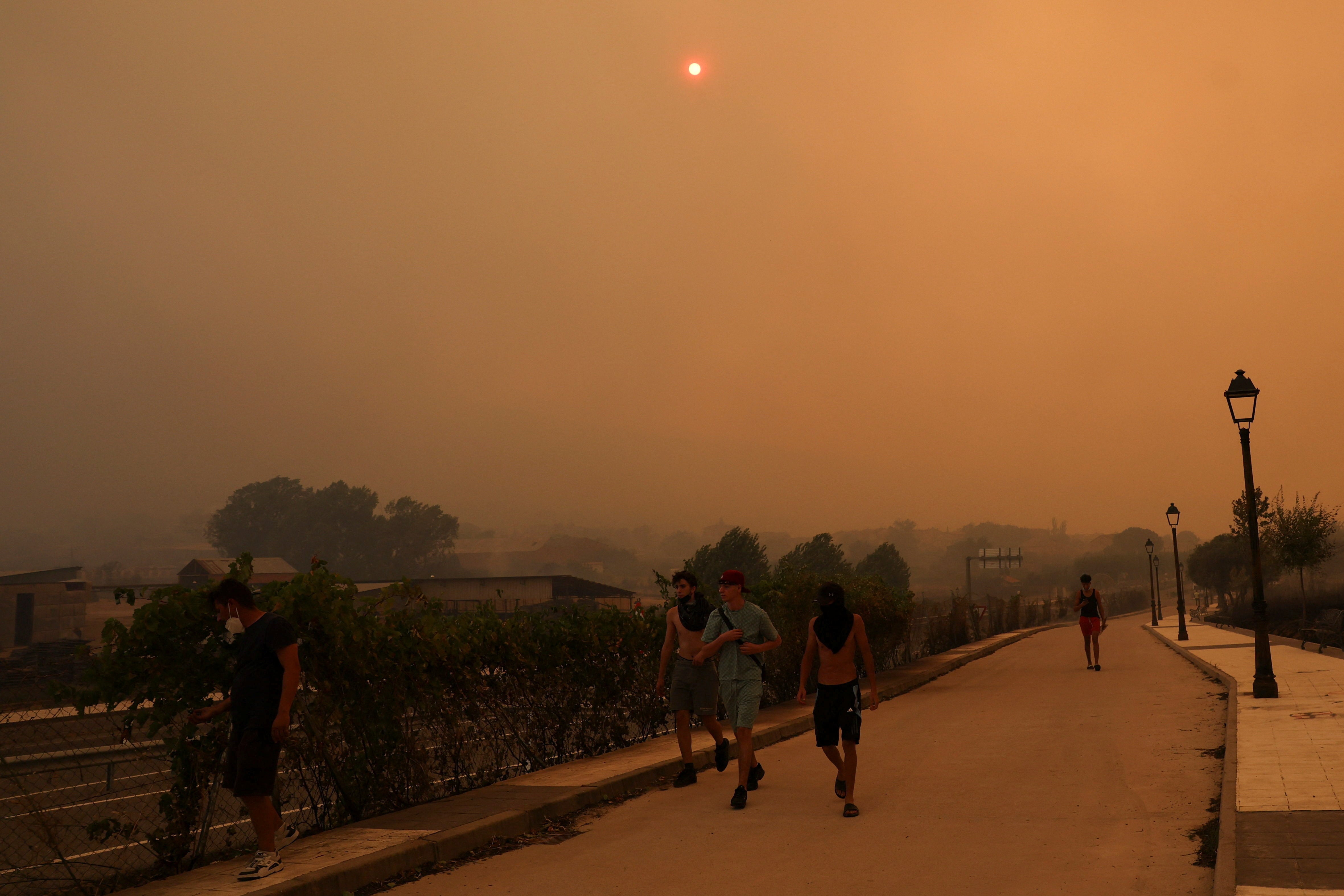 Members of the Kiat Yack Martial Arts Academy of Spanish, Moroccan, Colombian and Romanian origin move to help extinguish flames around the academy in the village of El Tiemblo (Reuters)