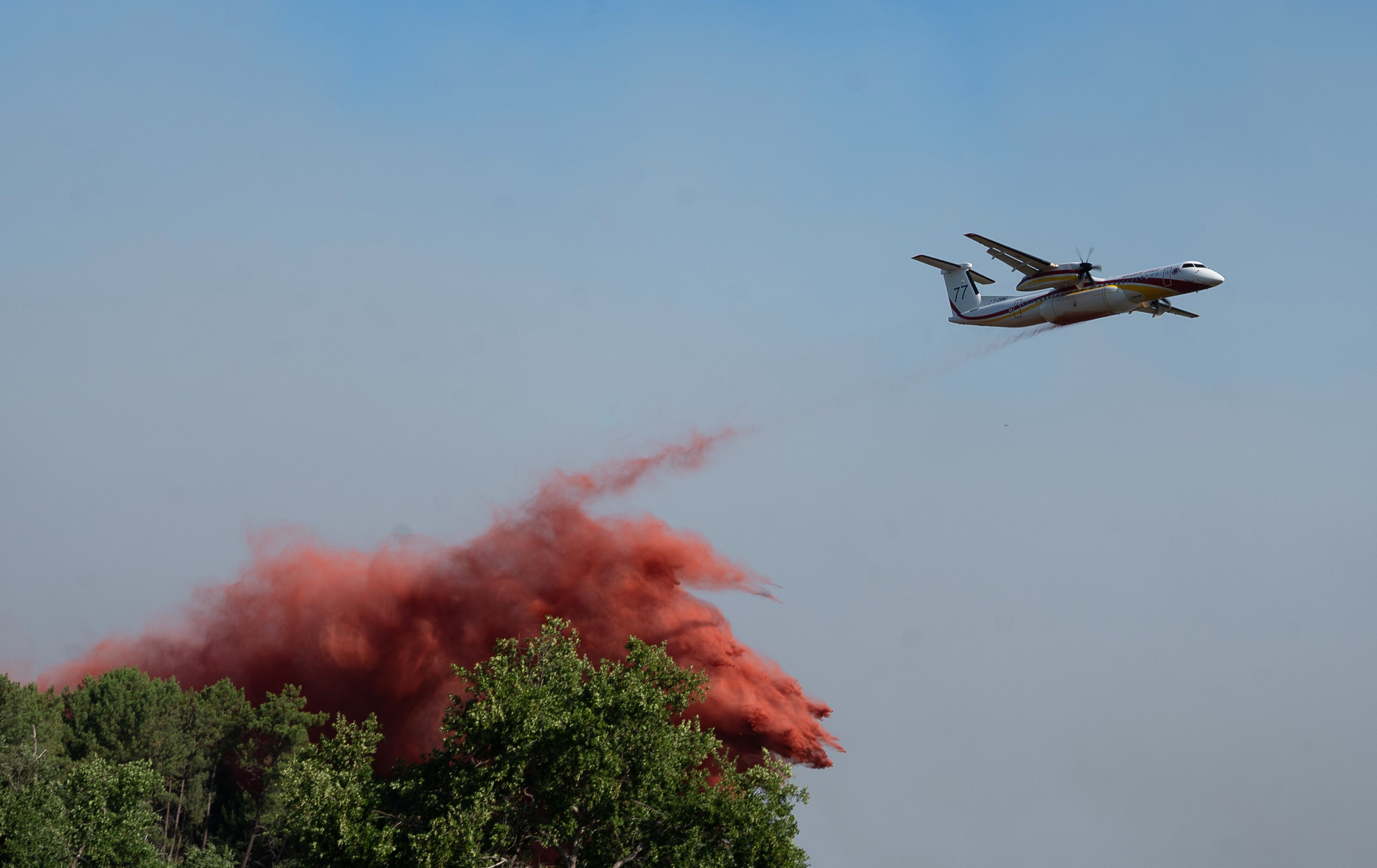 A water bomber drops water while fighting wildfires in Ares, western France