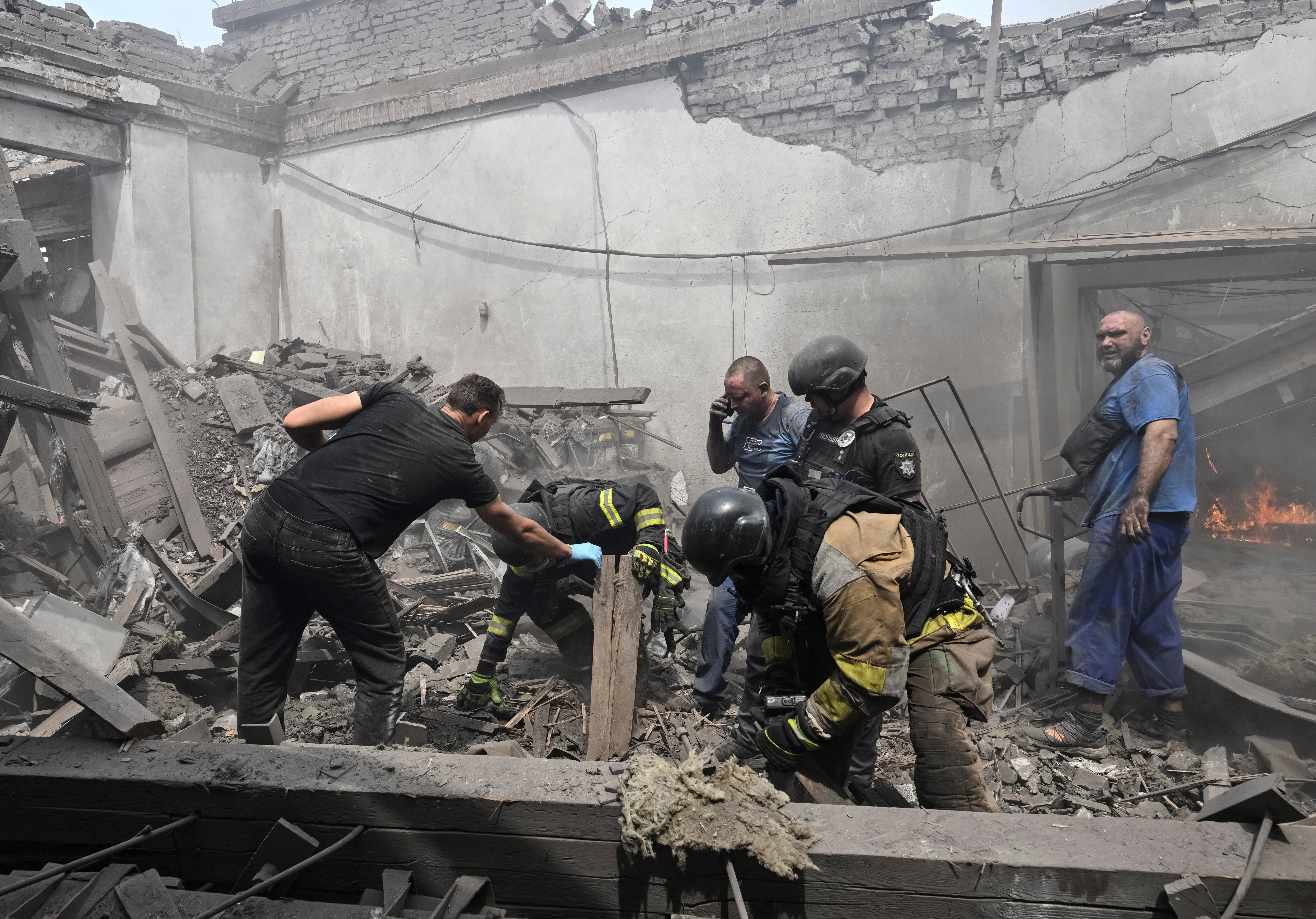 Rescuers and employers work at a site of the drinking water delivery company hit by a Russian air strike, amid Russia's attack on Ukraine, in Zaporizhzhia, Ukraine (Reuters)