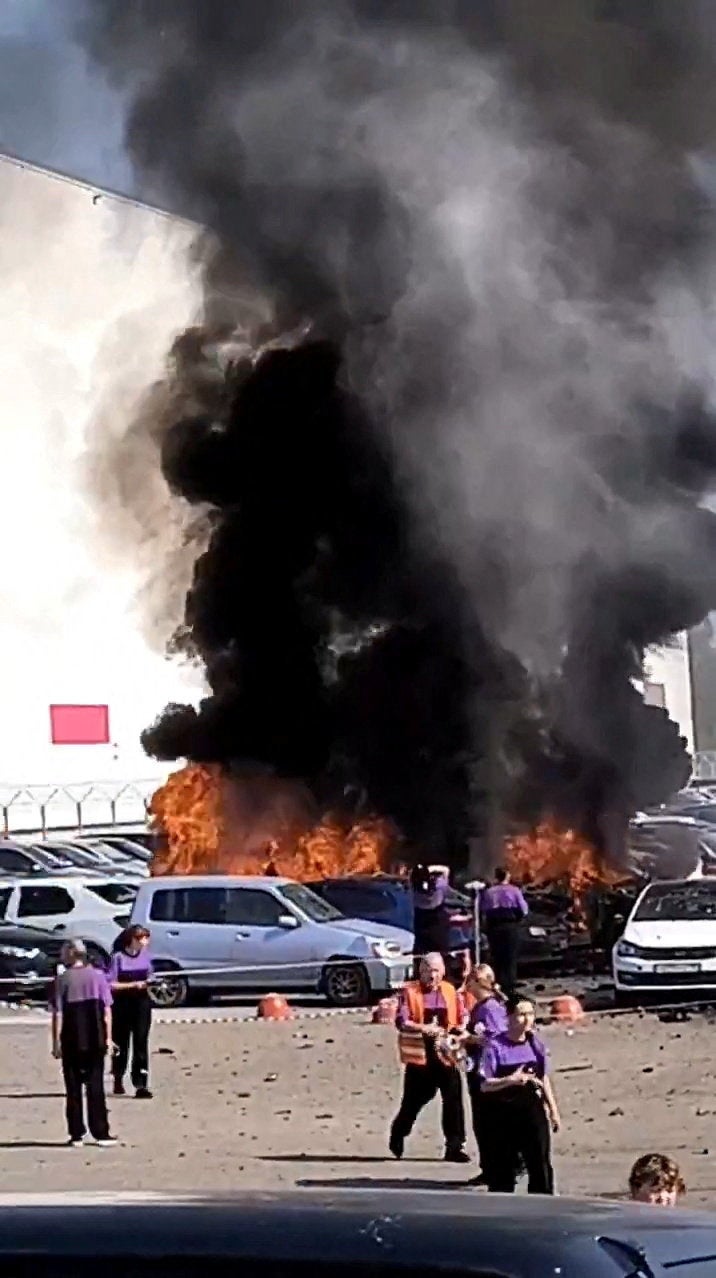 People react as smoke rises from Wildberries warehouse, in Yekaterinburg, Russia. Denis Pasler, governor of the ​Sverdlovsk region, said  that an attempted UAV attack caused a 300-square-meter fire in a parking lot in the Chkalovsky District of Yekaterinburg. (Reuters)