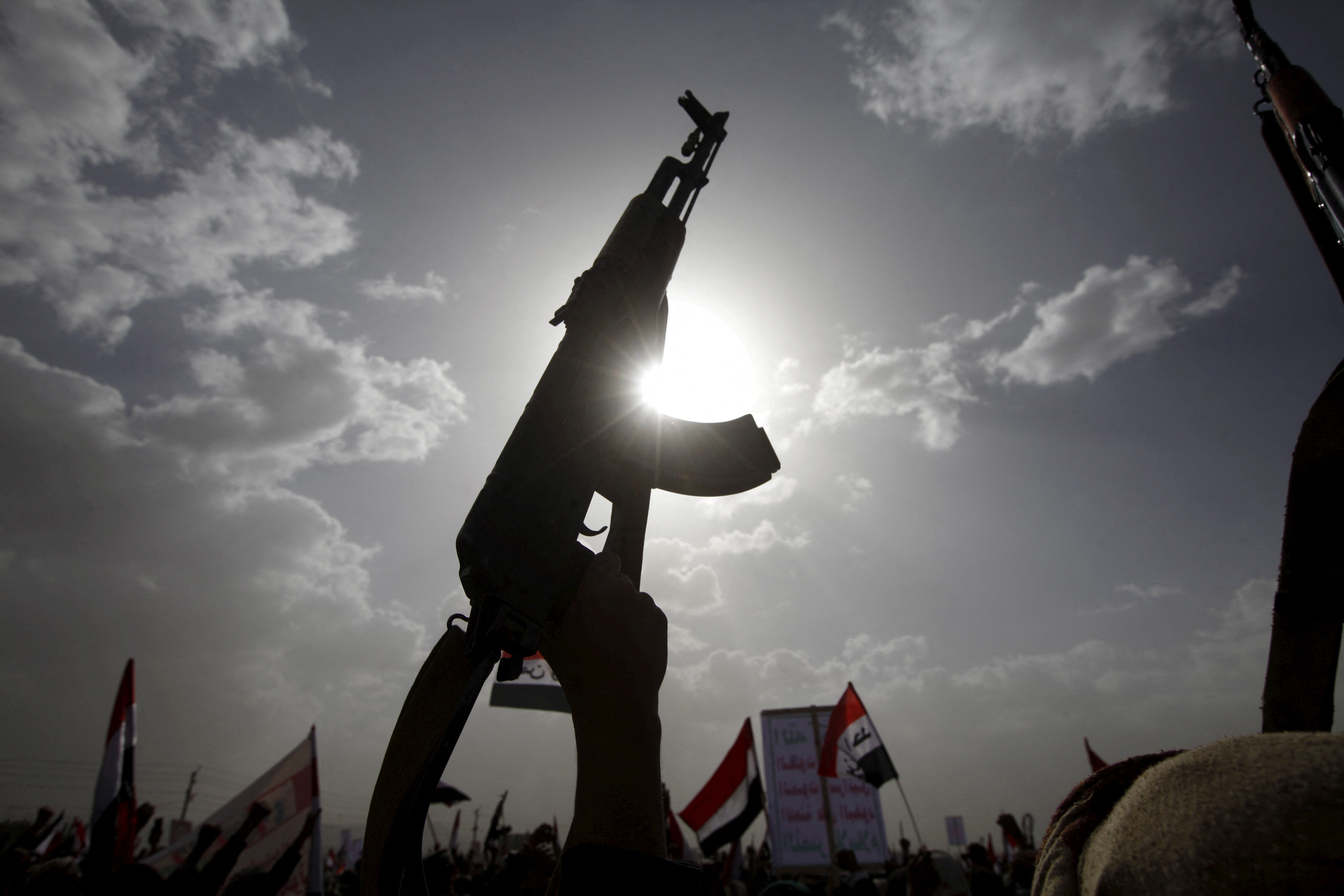 A Houthi follower rises a weapon as he attends a rally marking one year of Saudi-led air strikes (Reuters)