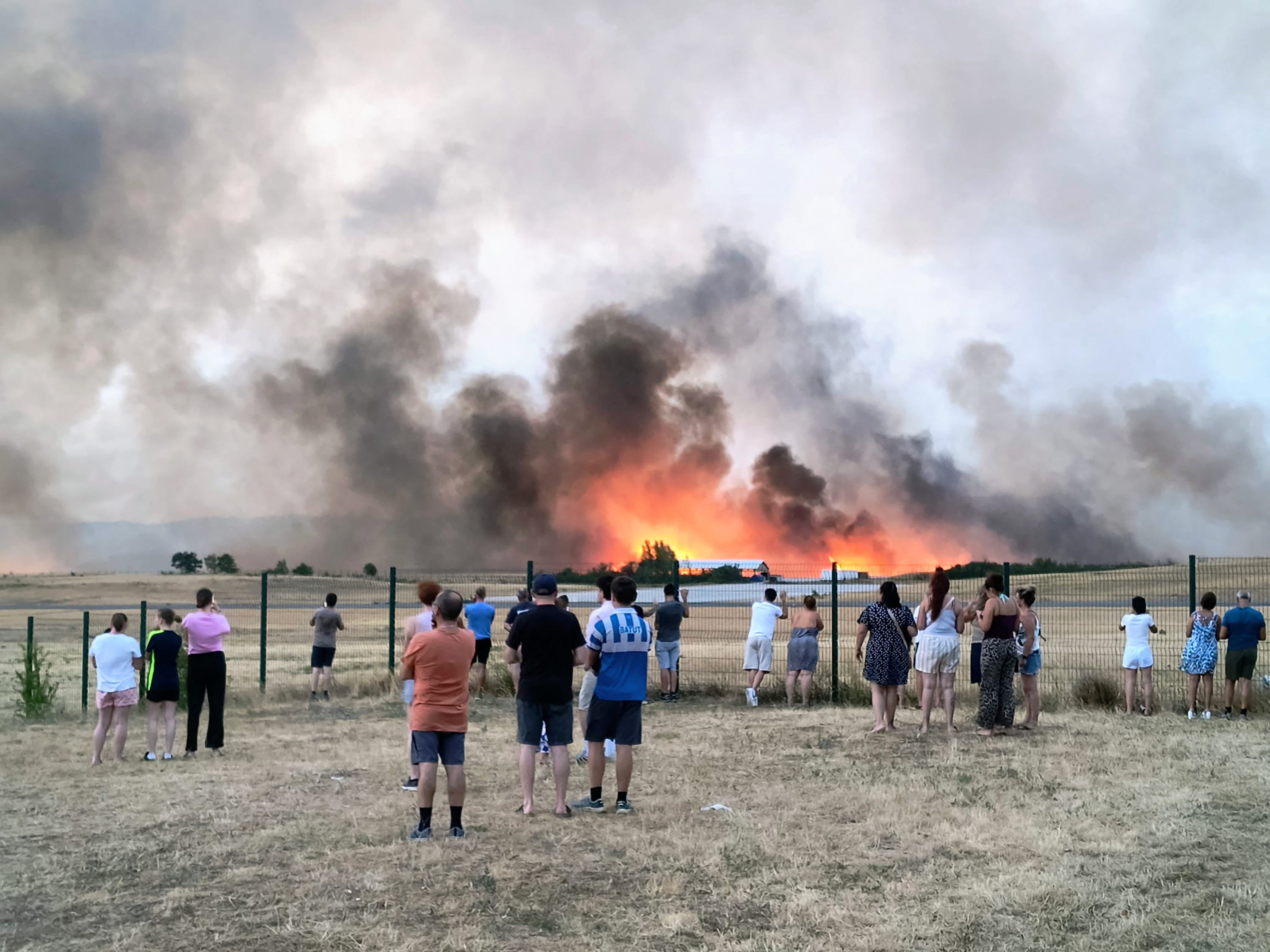 Bystanders look on as fire and smoke billow across Castres-Mazamet aerodrome, near Labruguiere in south-western France (AFP/Getty)