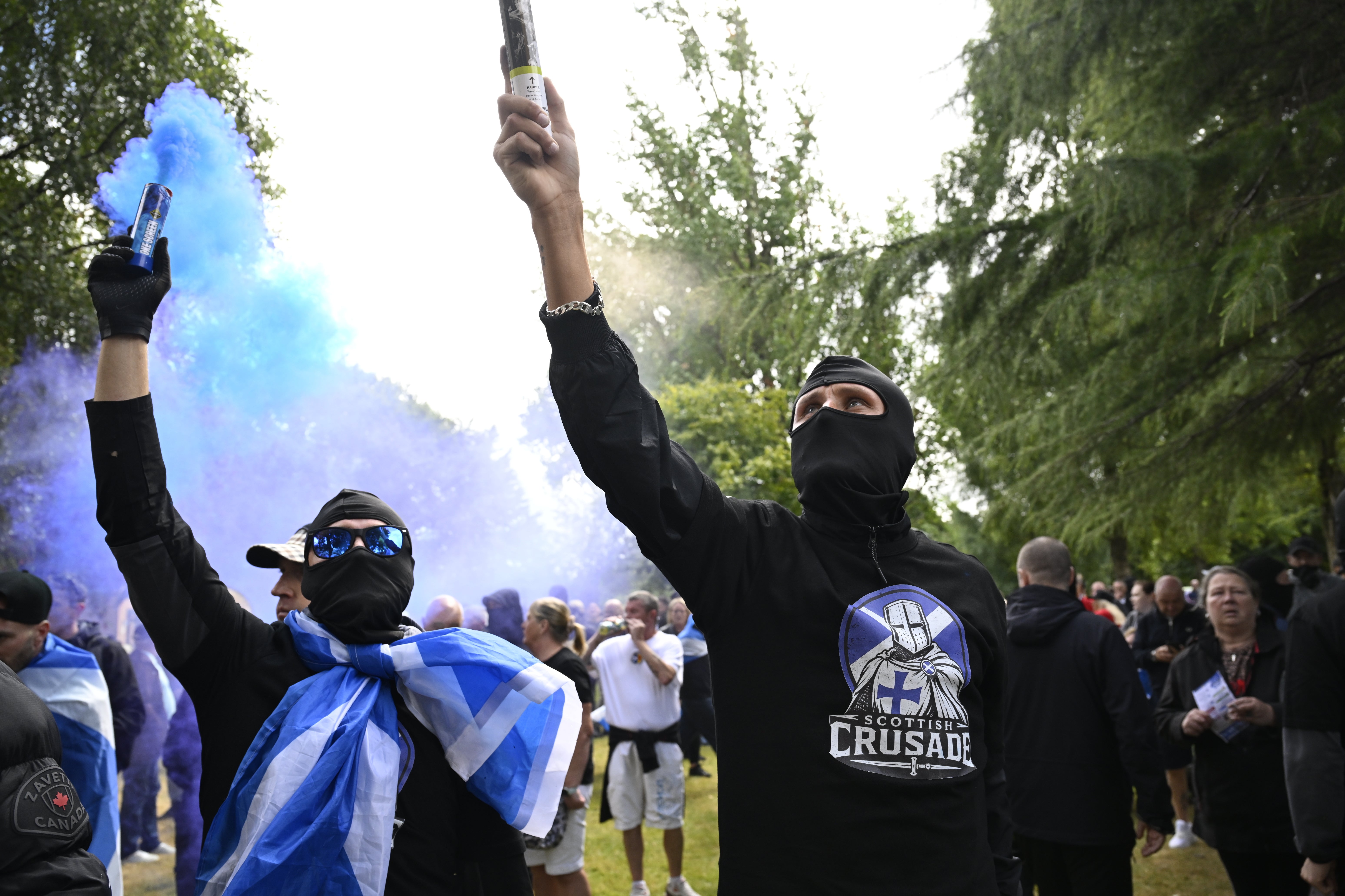Activists let off flares during the anti-immigration protest, organised by Unite the Clans Scotland, at Glasgow Green