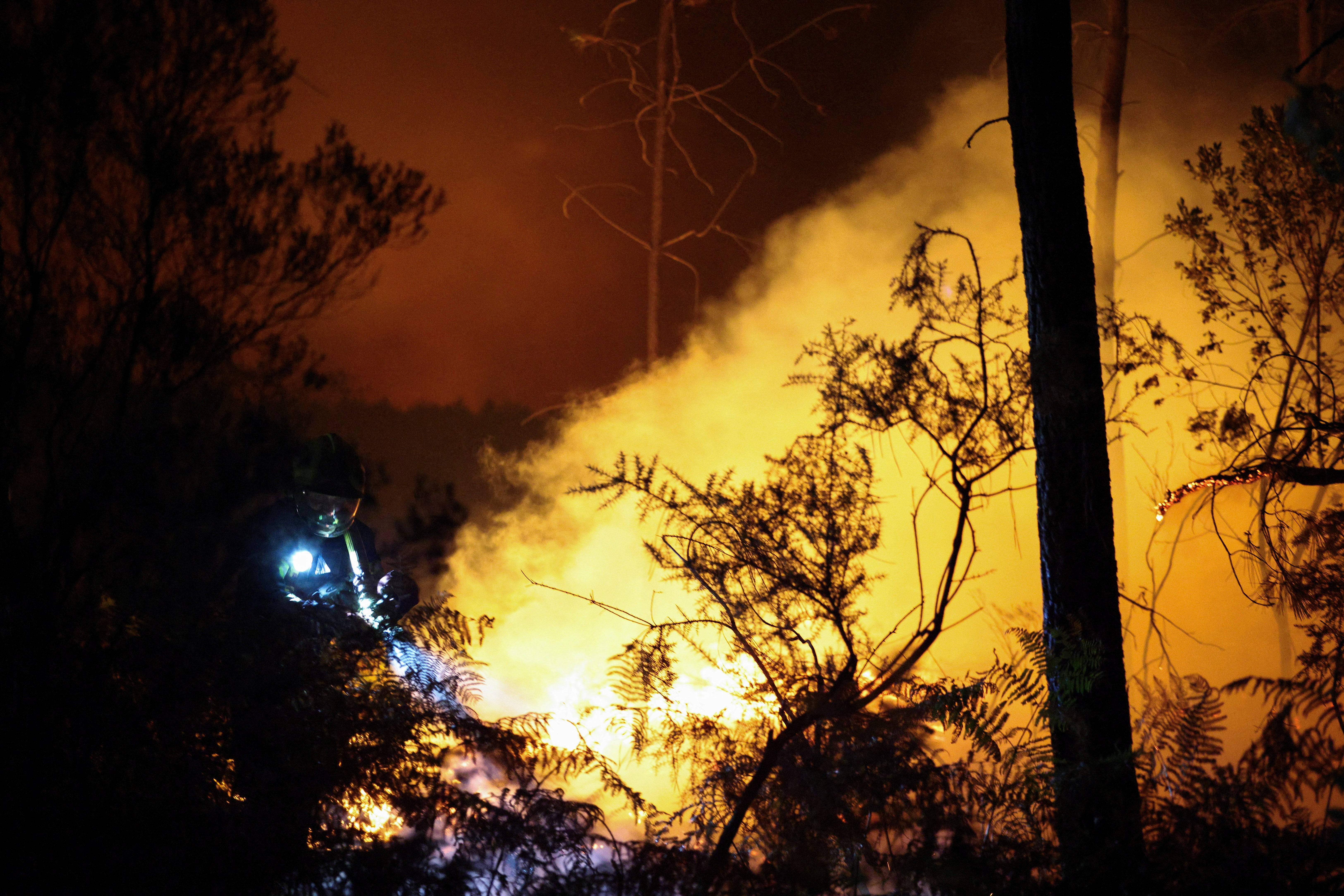 A firefighter works at the scene of a wildfire in Andernos-les-Bains in the Gironde department, amongst worsening drought conditions following a heatwave and water shortages across much of France, 26 July 2026