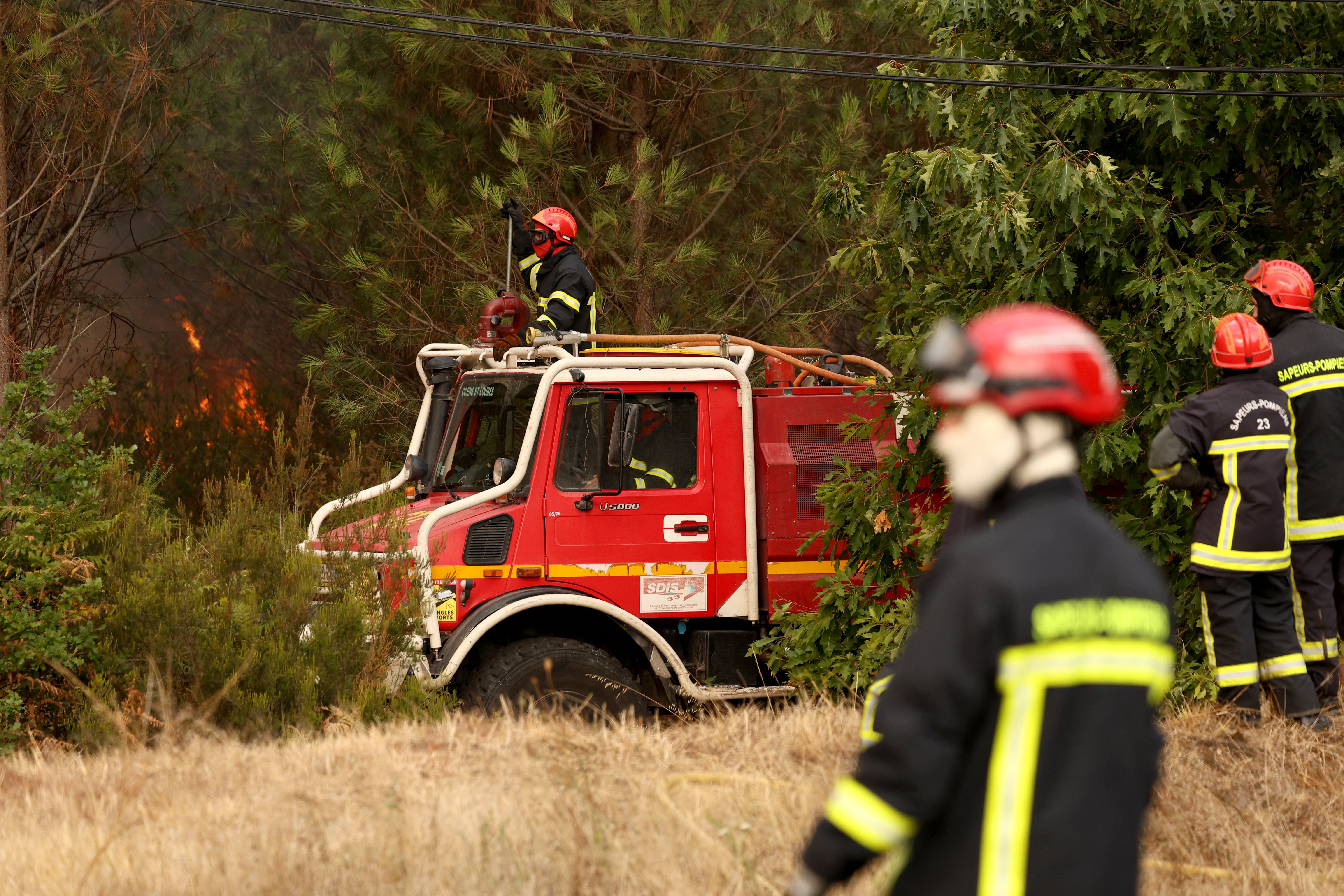 Firefighters work on the edge of a burning area in Blagon, west of Bordeaux, on July 26, 2026 as a wildfire has been ravaging the forest north of the Arcachon Basin (Gironde) since July 22