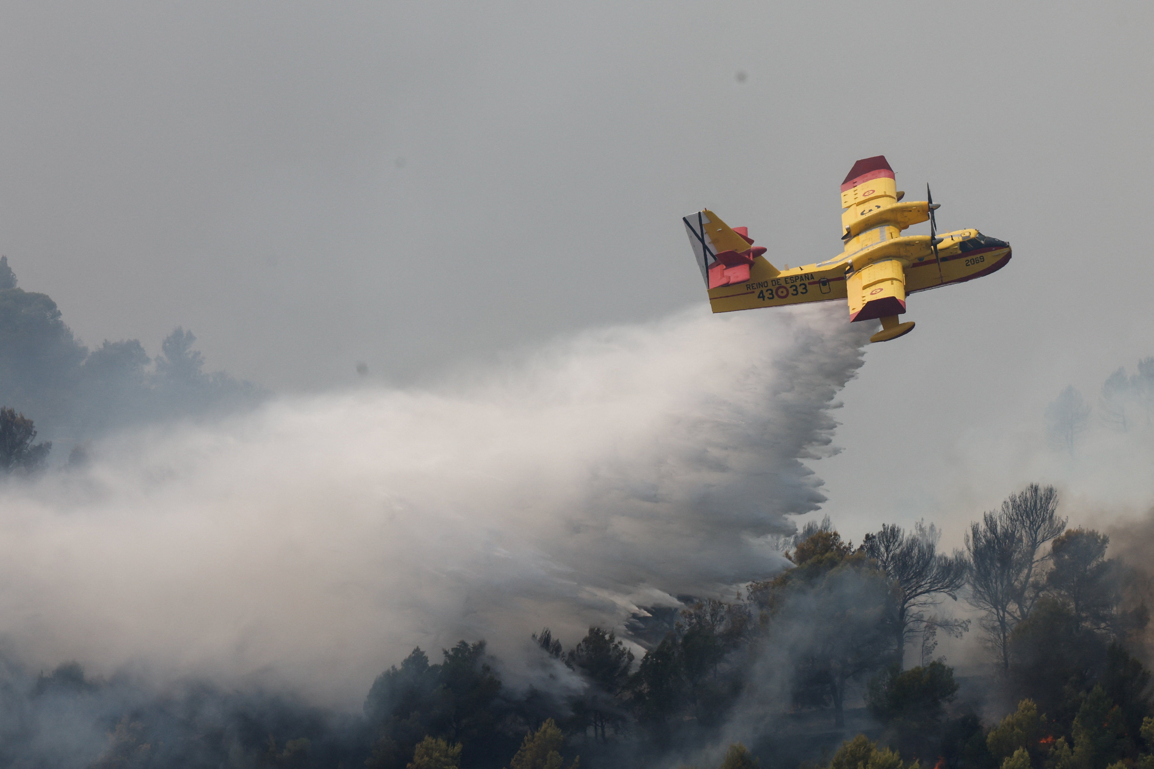 A firefighting plane makes a drop during a wildfire in Betxi, Spain, July 26, 2026 (Reuters)