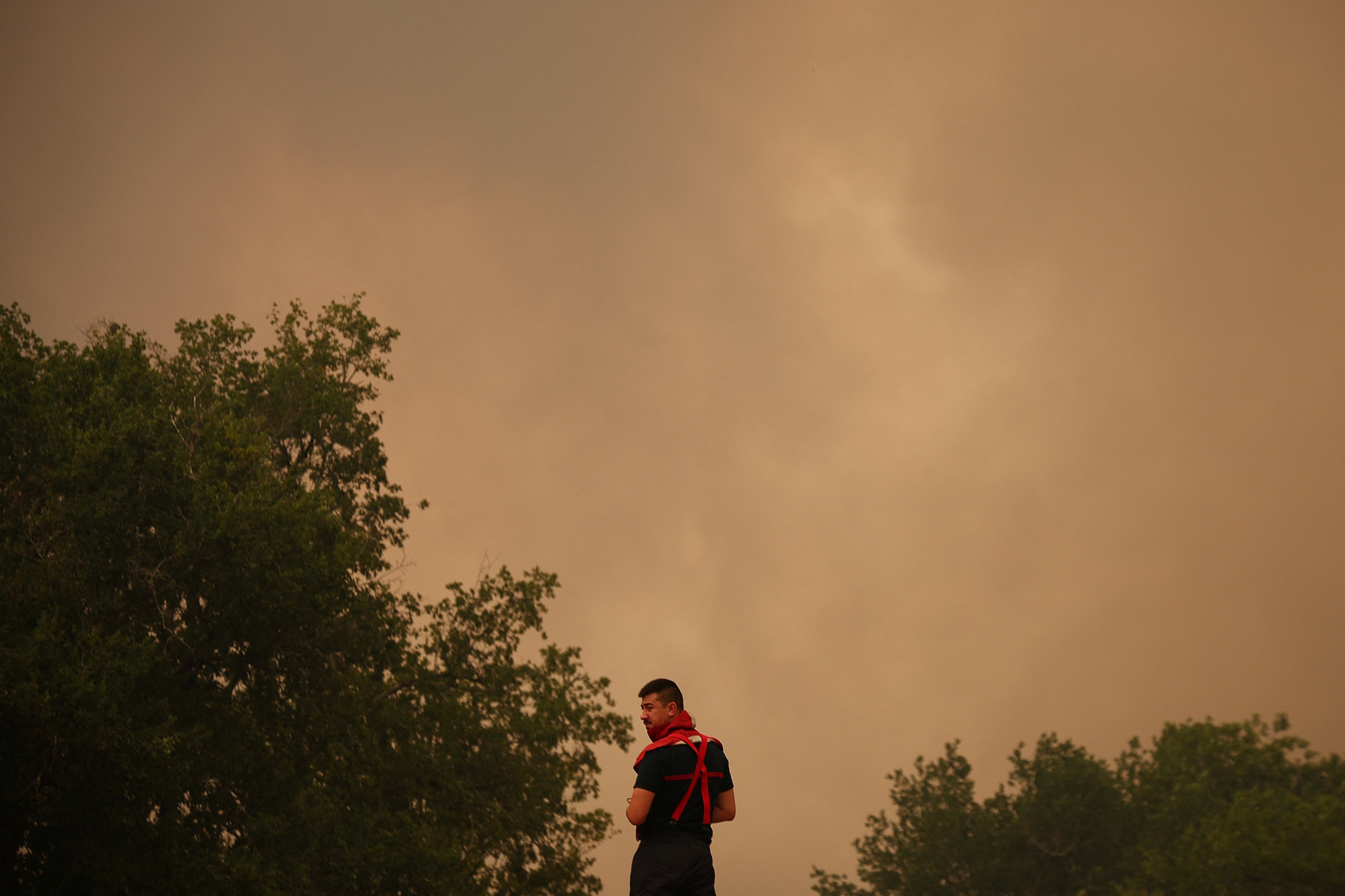 A firefighter looks on, as a wildfire burns nearby, amid worsening drought conditions following a heatwave and water shortages across much of France, in Pierroton, Gironde, France, July 26, 2026.