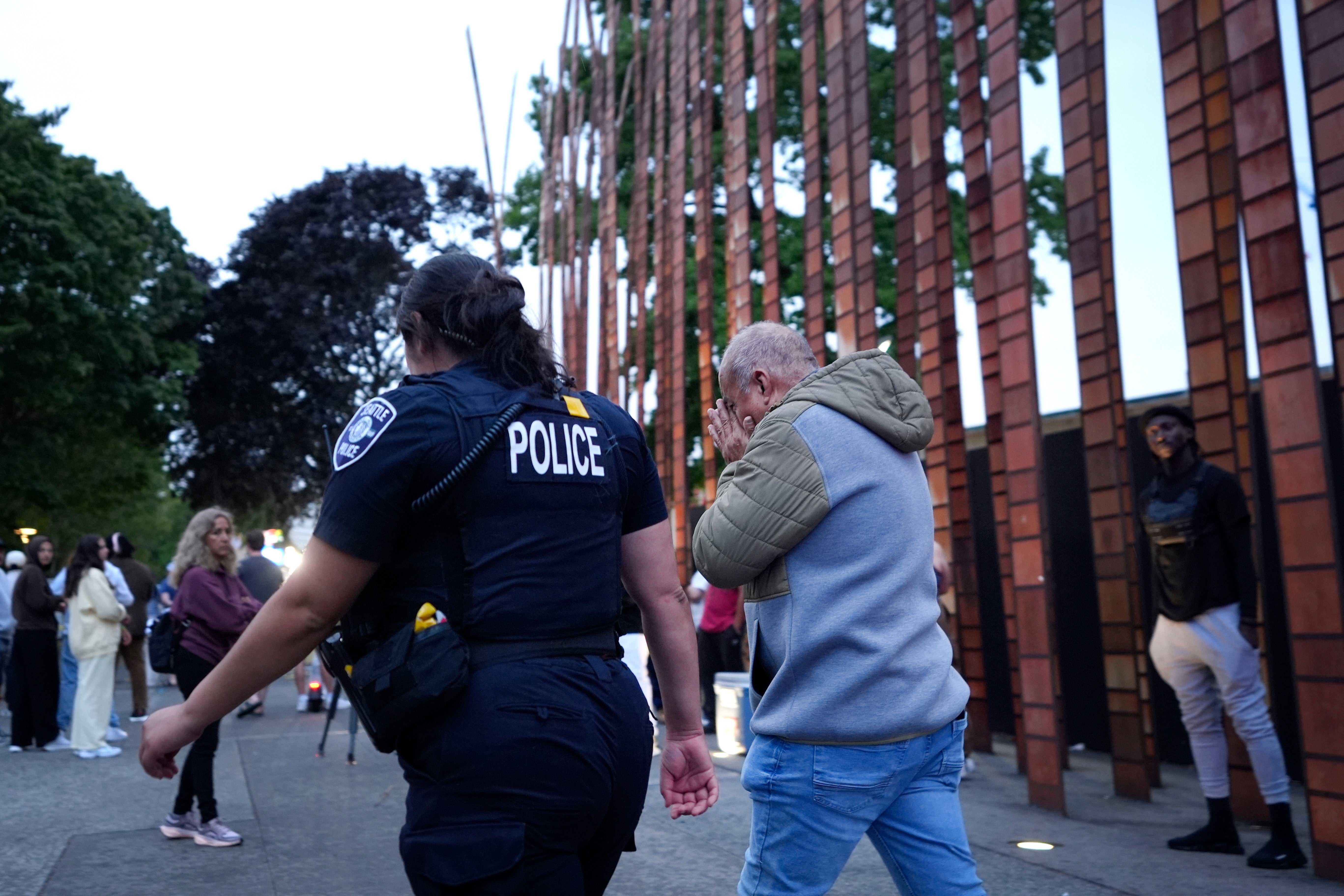 An unidentified man is led into a shooting scene by police after they responded to a shooting at Seattle Center during the Bite of Seattle food festival Sunday, 26 July 2026, in Seattle, Wash (AP)