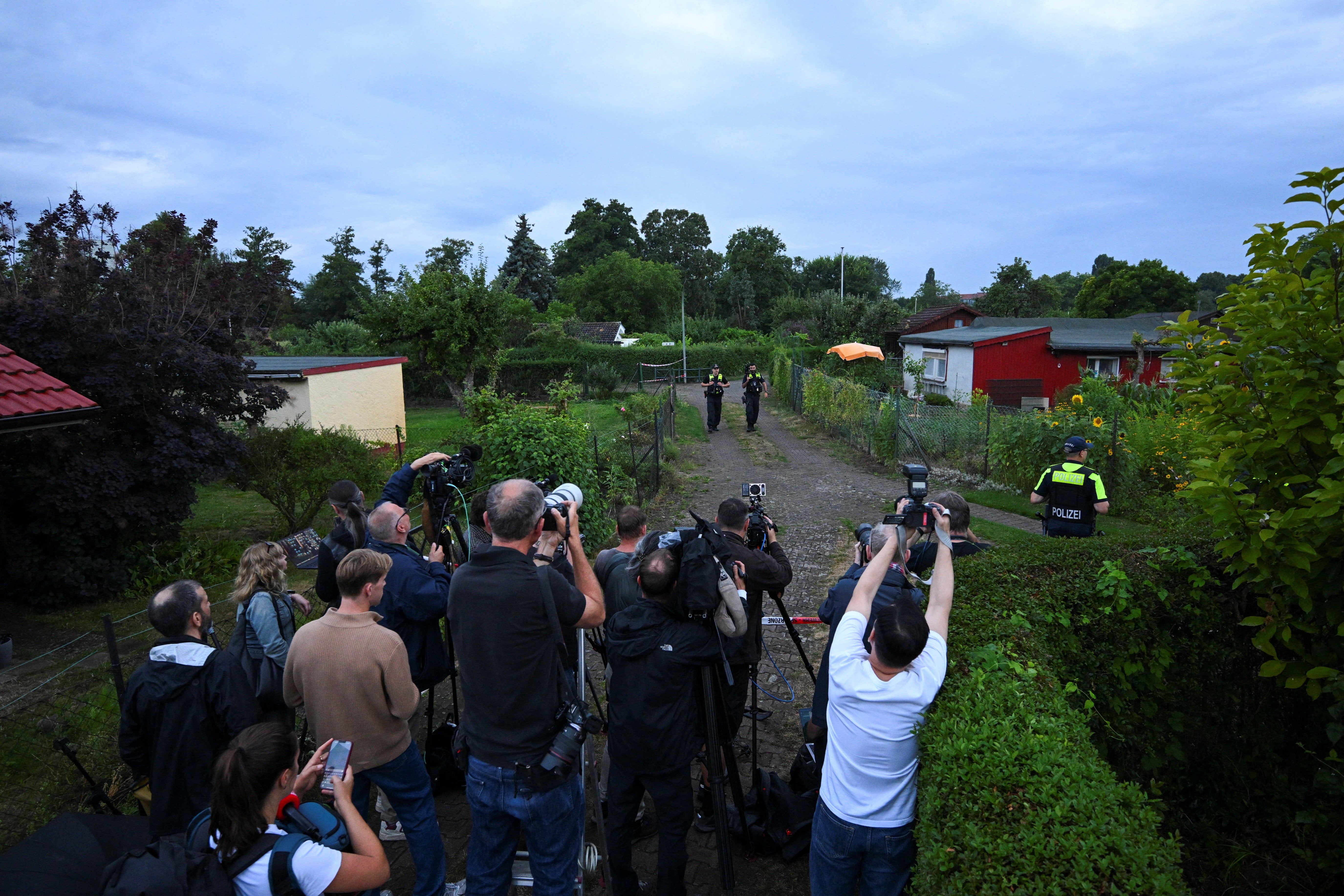 Police secure the area at an allotment garden complex in the Berlin suburb of Spandau, after a known Islamist, suspected of ramming a minivan into a crowd near Berlin's annual Christopher Street Day Pride parade on Saturday evening, was shot and killed in a police operation