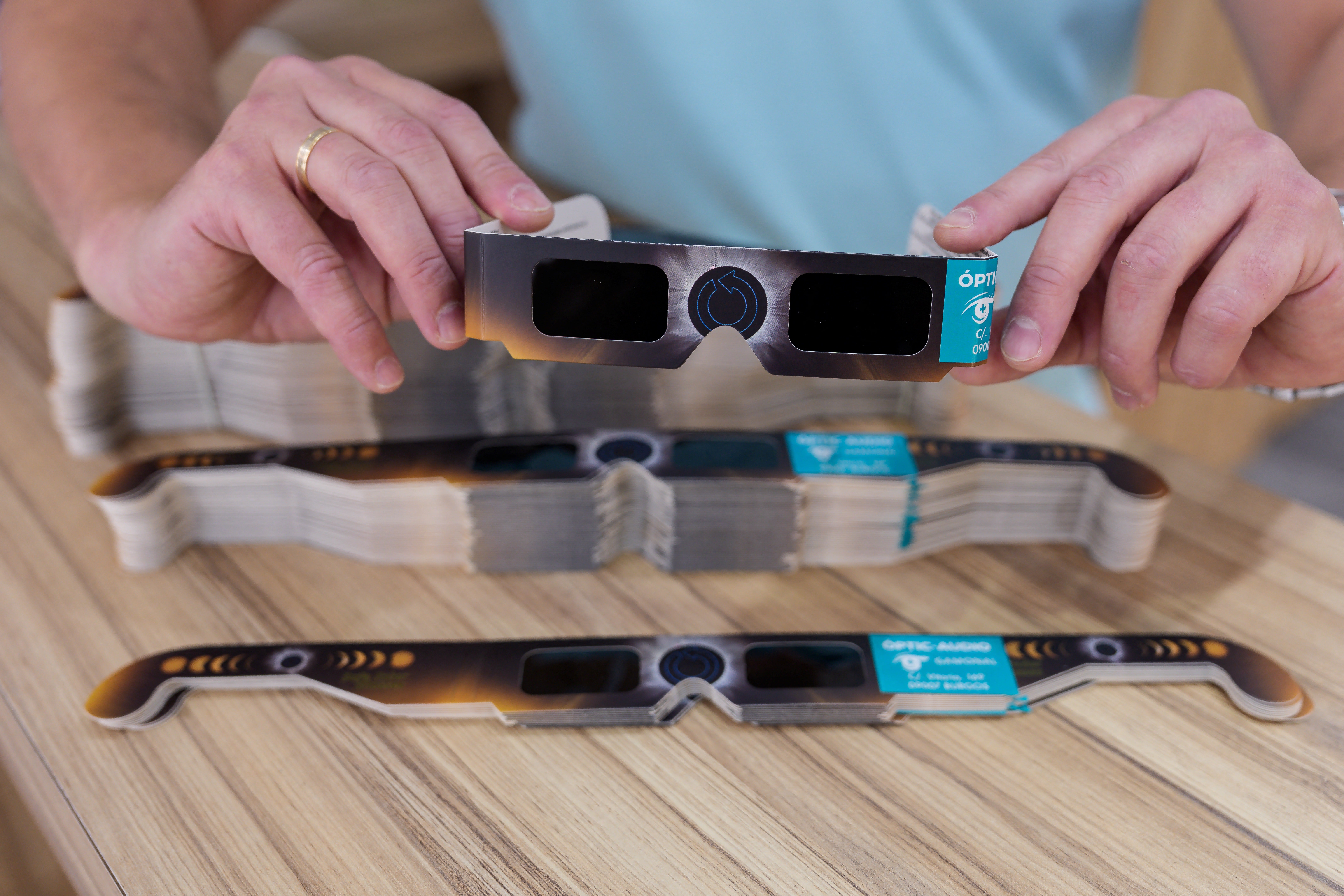 A man holds eclipse-viewing glasses that are certified to the ISO 12312-2:2015 international safety standard