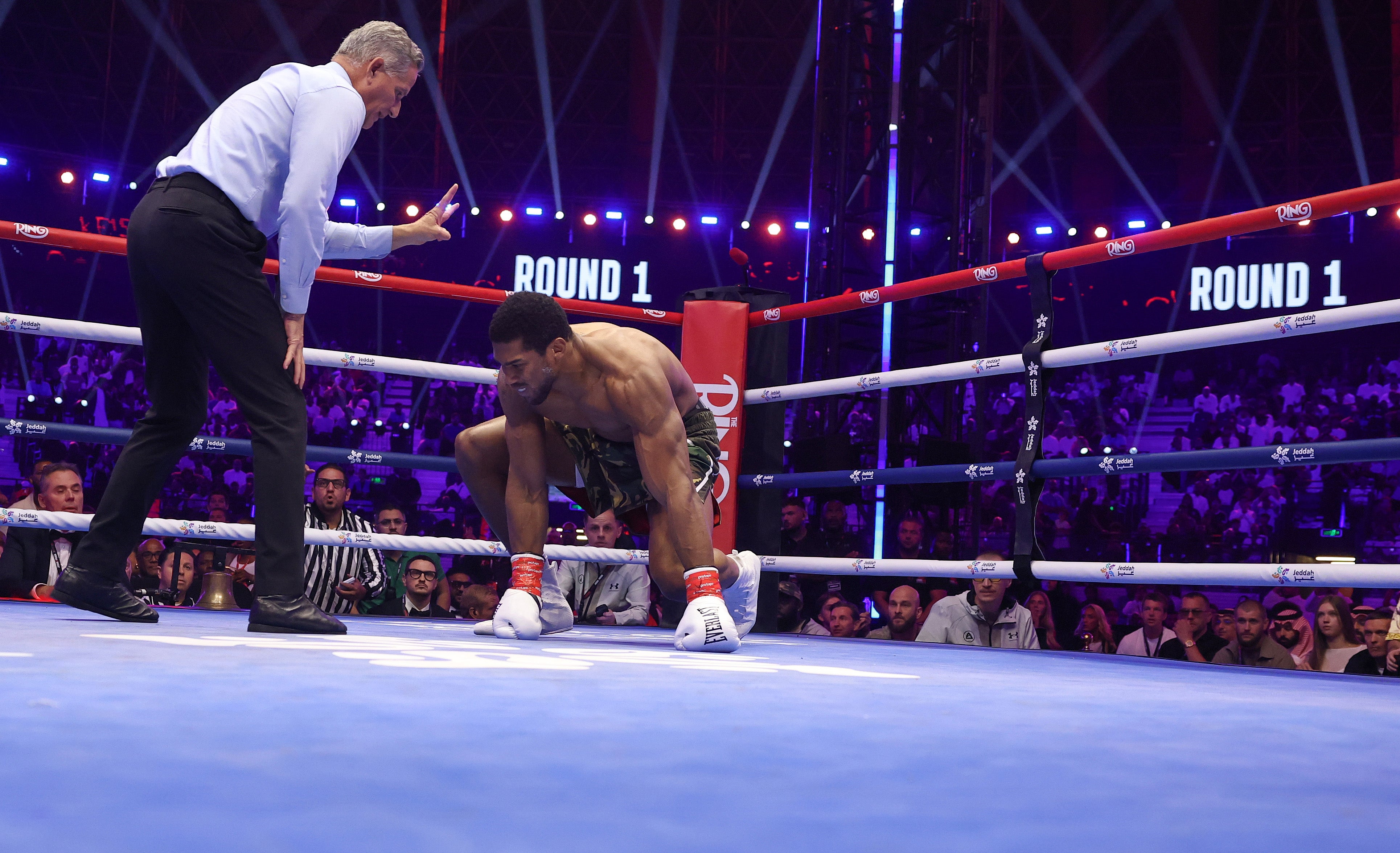 Joshua climbs off the canvas after one of two first-round knockdowns