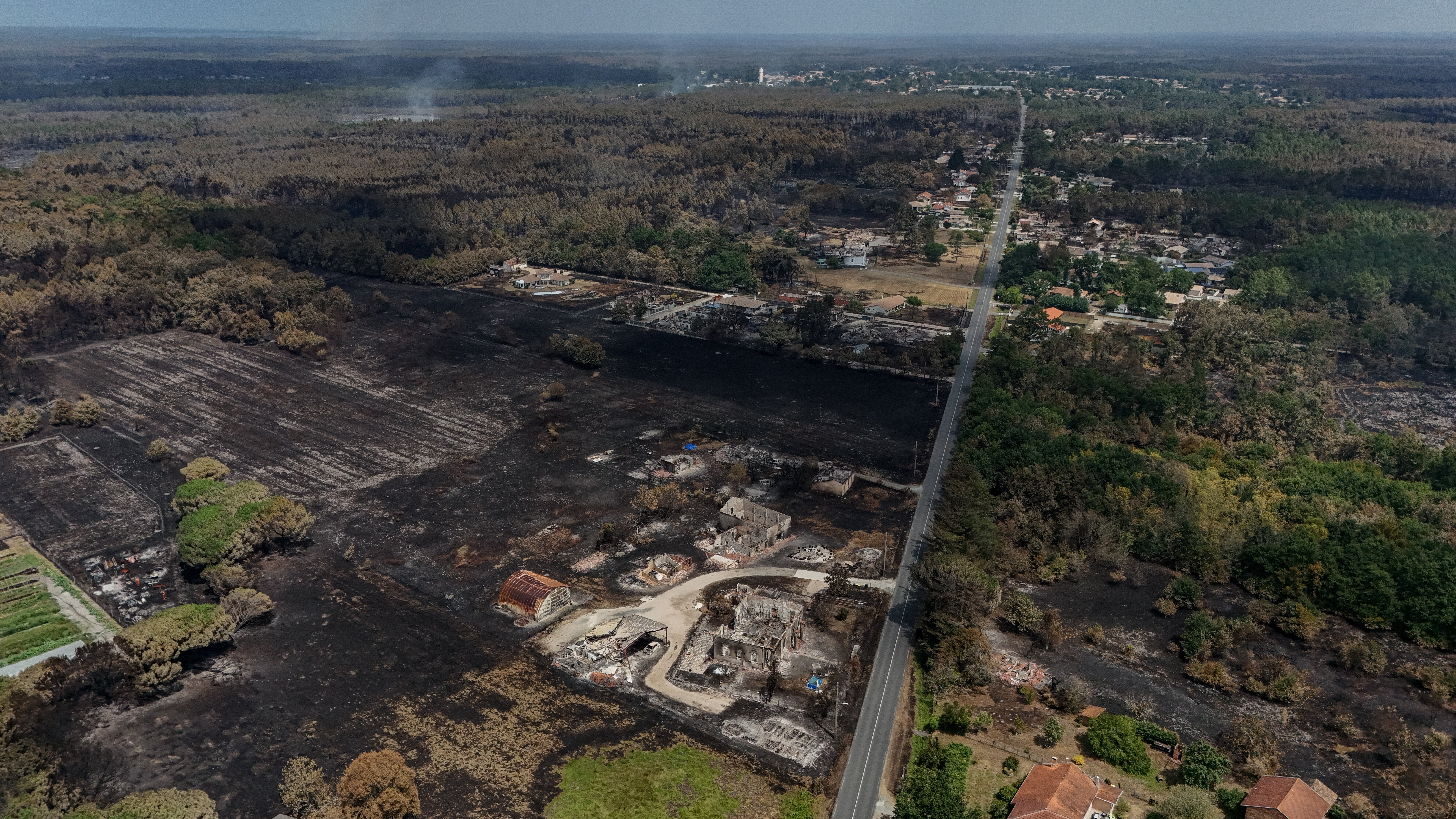 This aerial view shows damaged houses in a burnt area in the French town of Le Porge