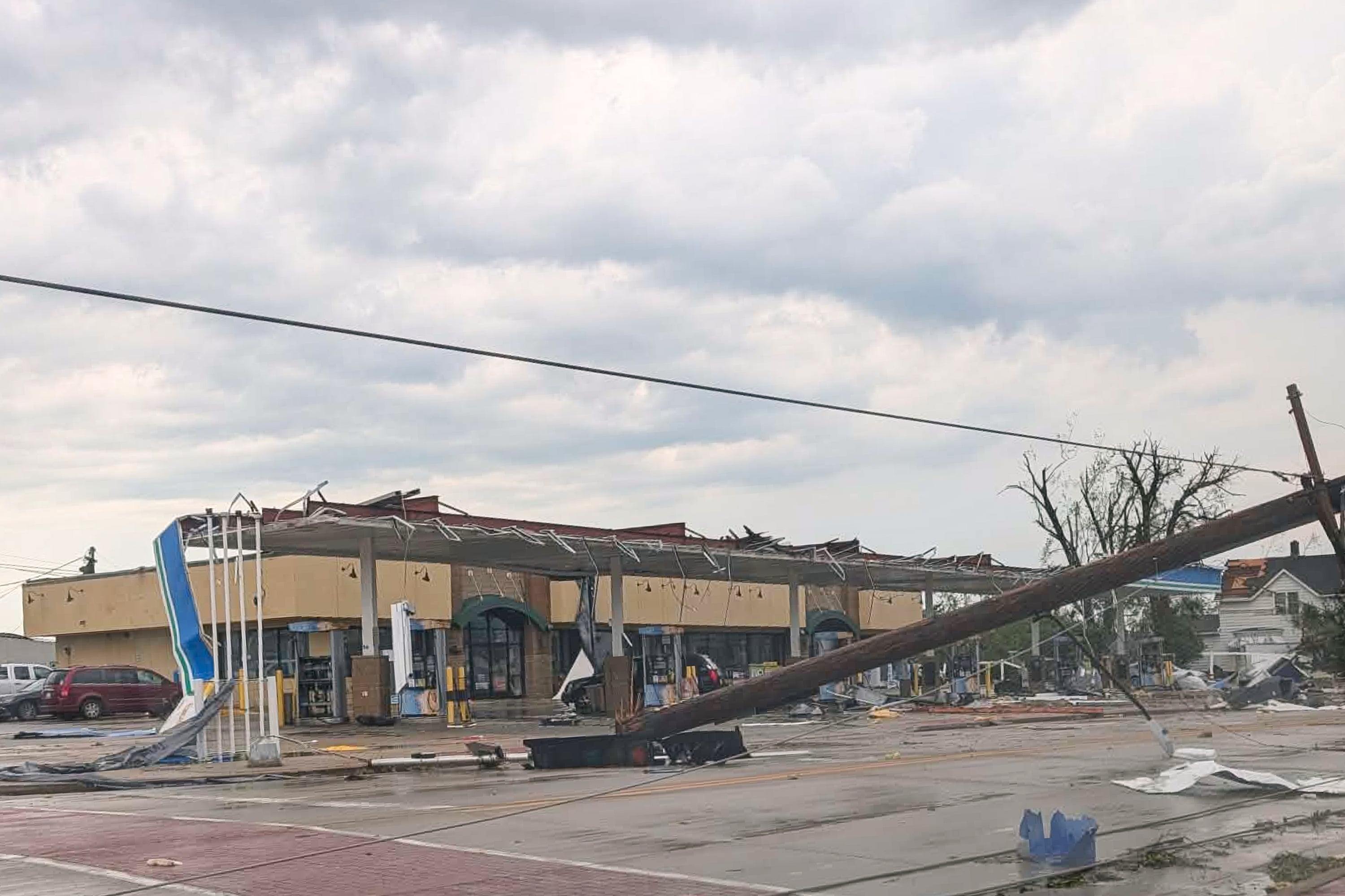 A telephone pole dangles from power lines in Menasha, Wisconsin, after severe thunderstorms tore through the region Monday. The same weather system produced the flooding in Downers Grove that trapped two contractors in a sewer pipe (AP)
