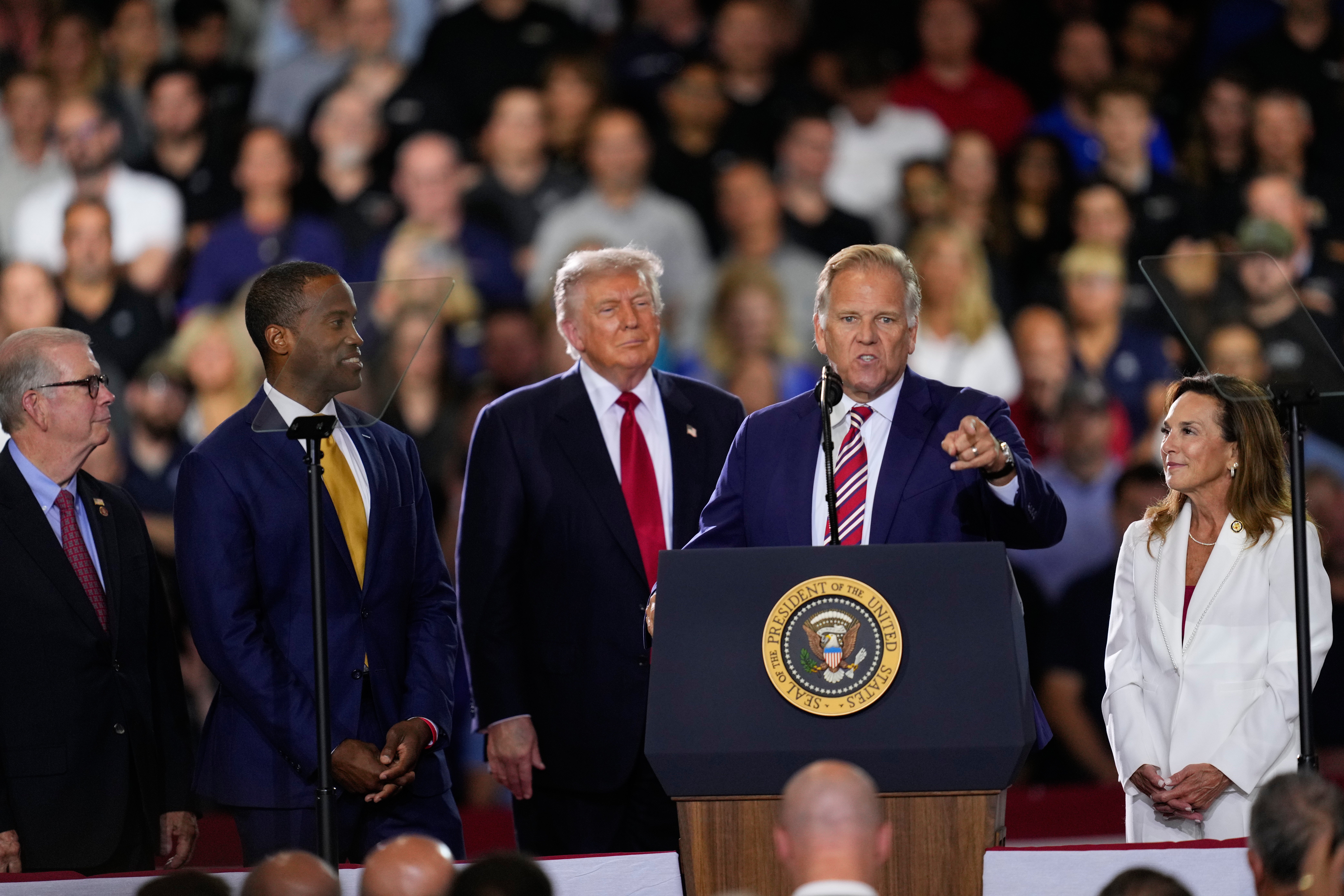 Republican Senate candidate Mike Rogers speaks as Rep. Tim Walberg, R-Mich., Rep. John James, R-Mich., President Donald Trump and Rep. Lisa McClain, R-Mich., listen at an event at the General Motors Proving Ground Monday (AP)