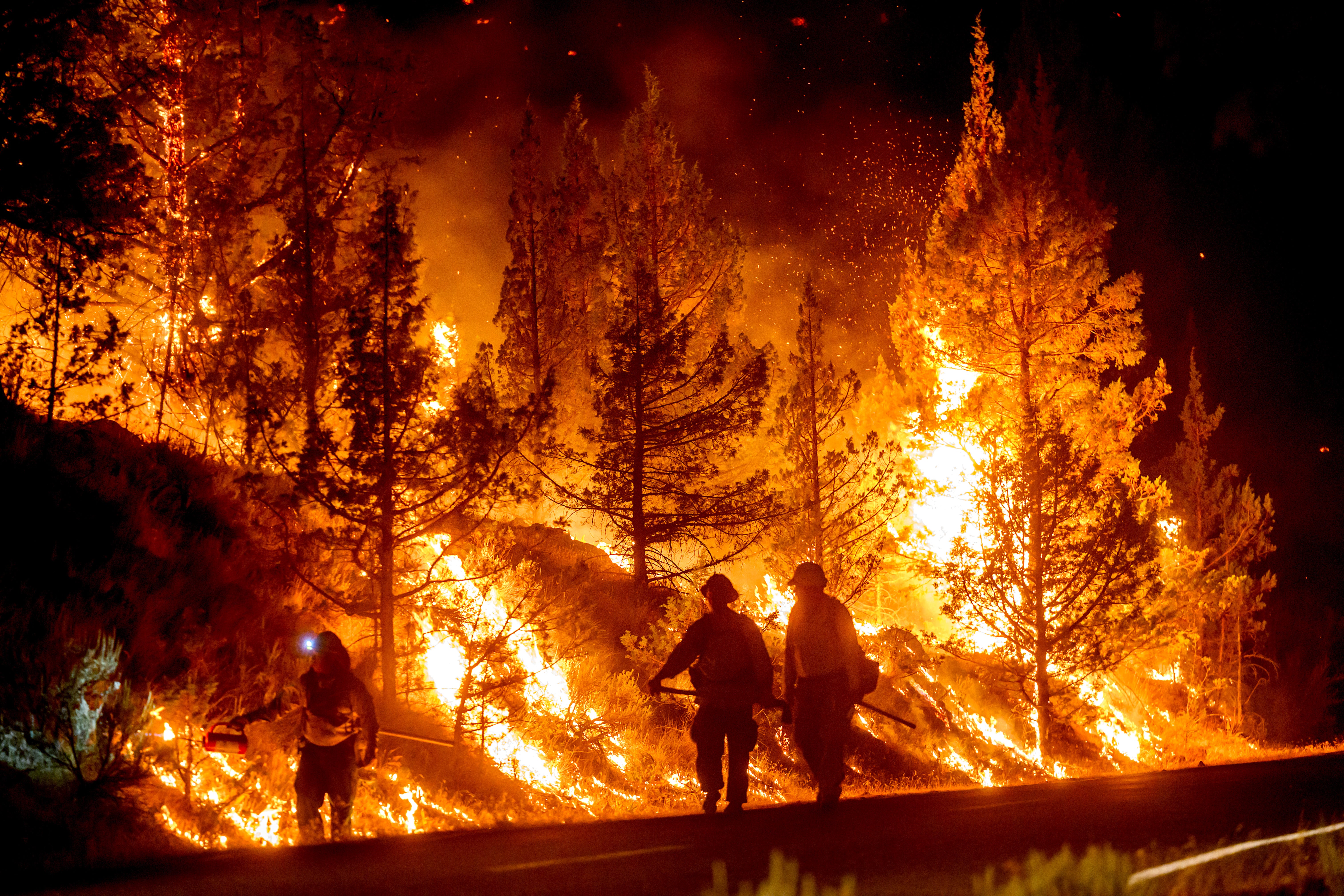 Firefighters burn off vegetation while trying to stop a wildfire called the Bench Fire from spreading in Warm Springs, Oregon