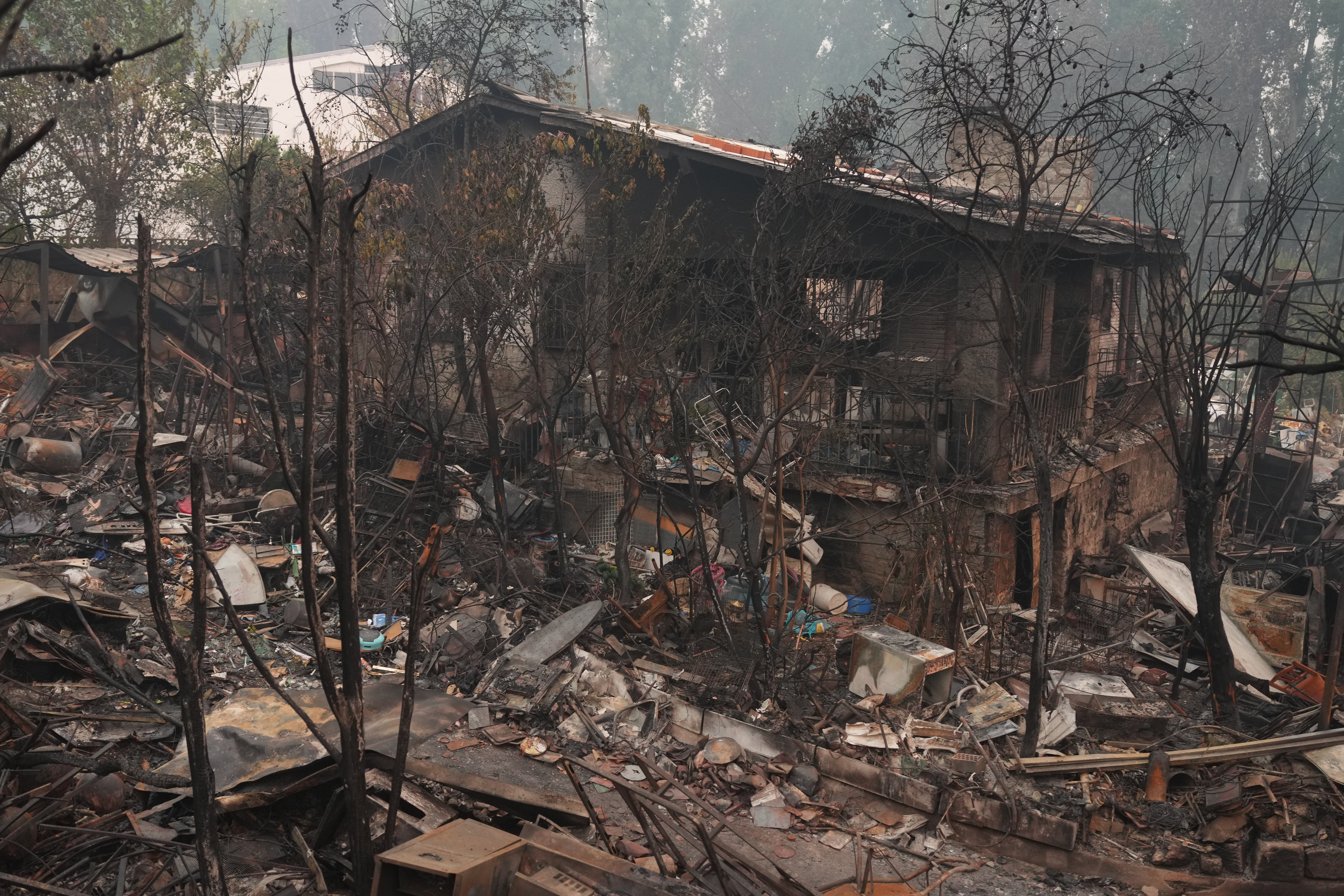 A house destroyed by a wildfire is photographed as the fire continues to spread in Pelayos de la Presa, Madrid province, Tuesday, July 28, 2026. (AP Photo/Manu Fernandez)