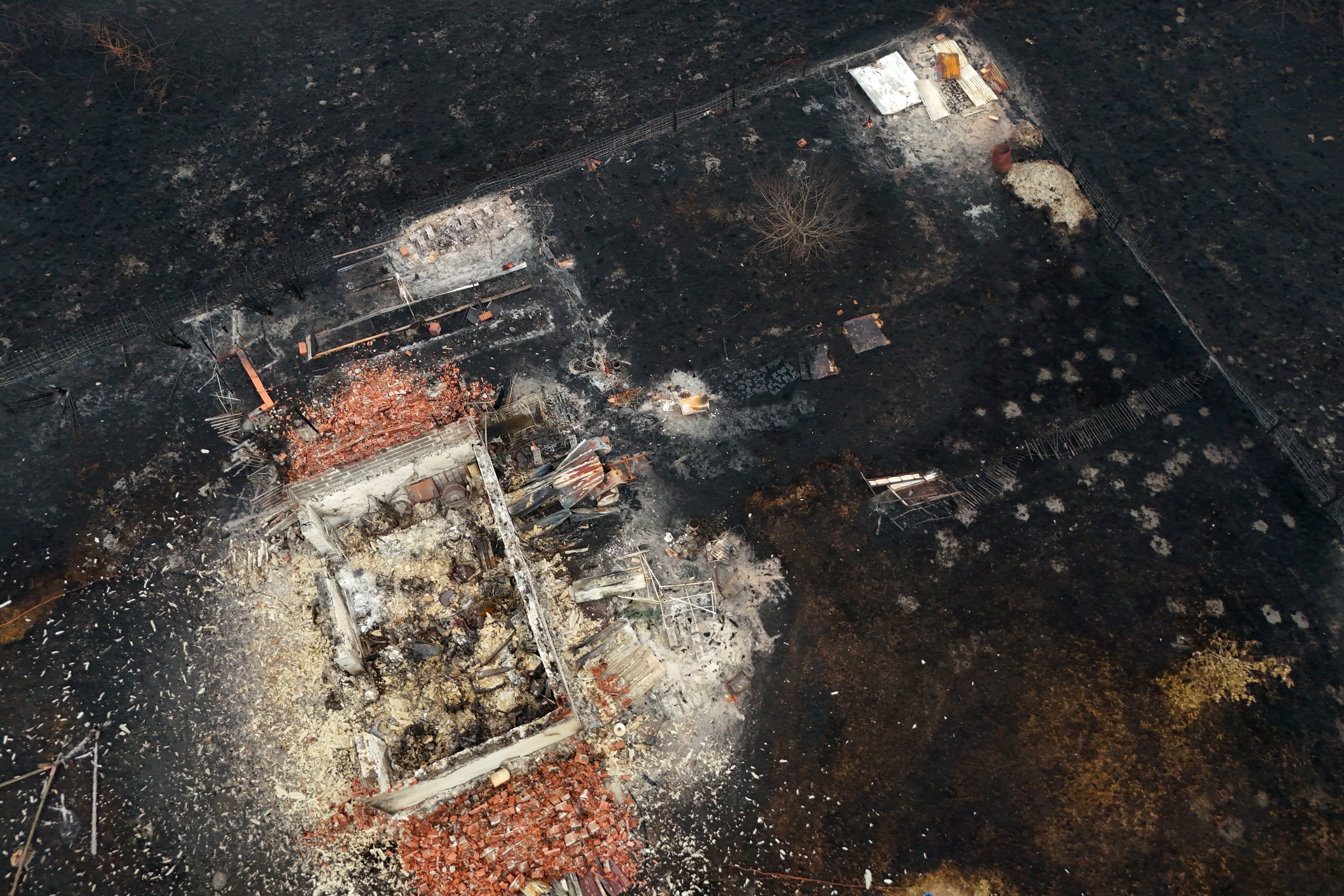 A drone view shows a burnt building in an area affected by a wildfire, in Le Porge, Gironde, amid drought conditions following a heatwave and water shortages across much of France, 27 July 2026