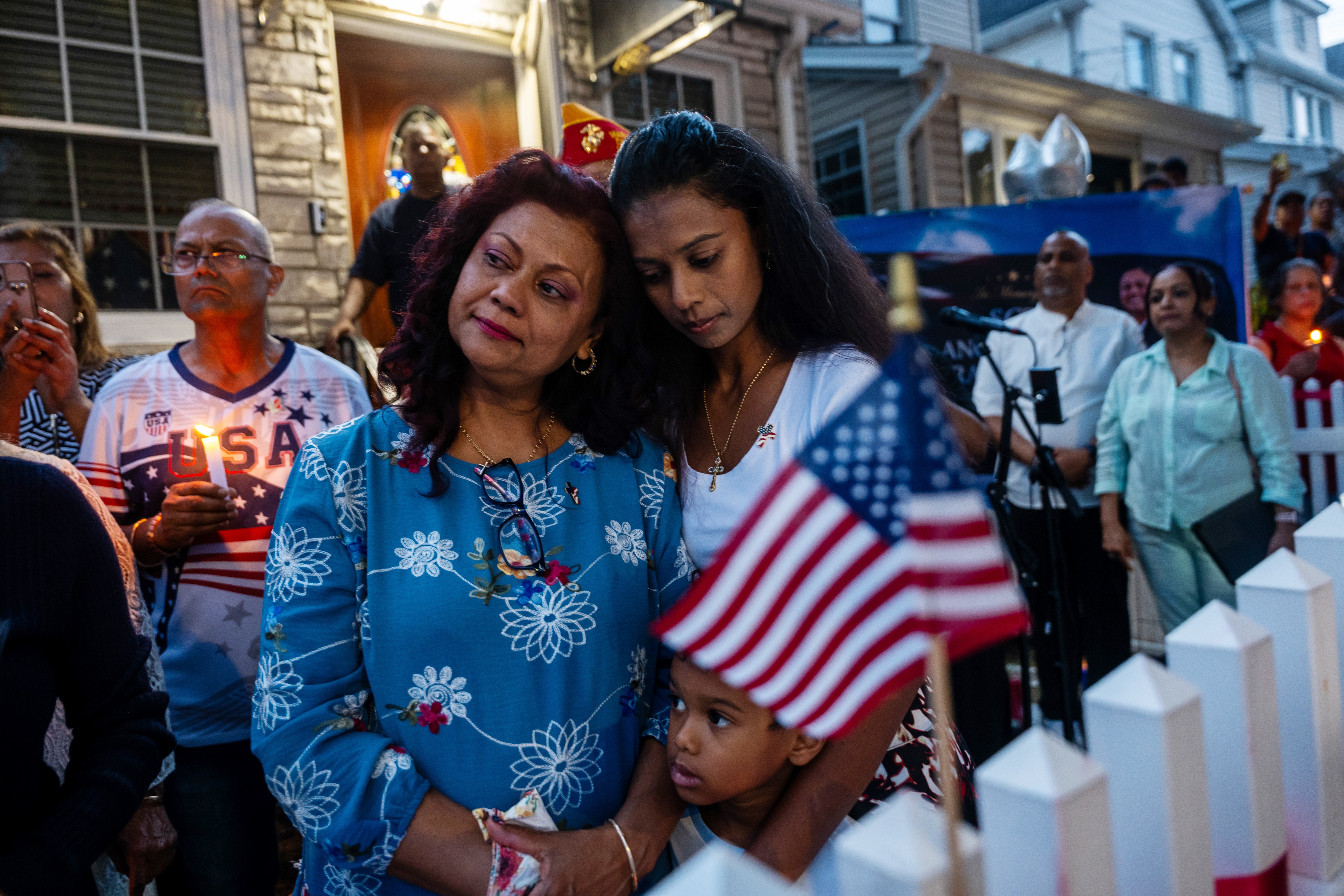 Carol Acevedo, center left, grieves with her family during a candlelight vigil for her daughter Army Sgt. Angel Rampersad in front of their home on July 27, 2026 in the Ozone Park area of New York City