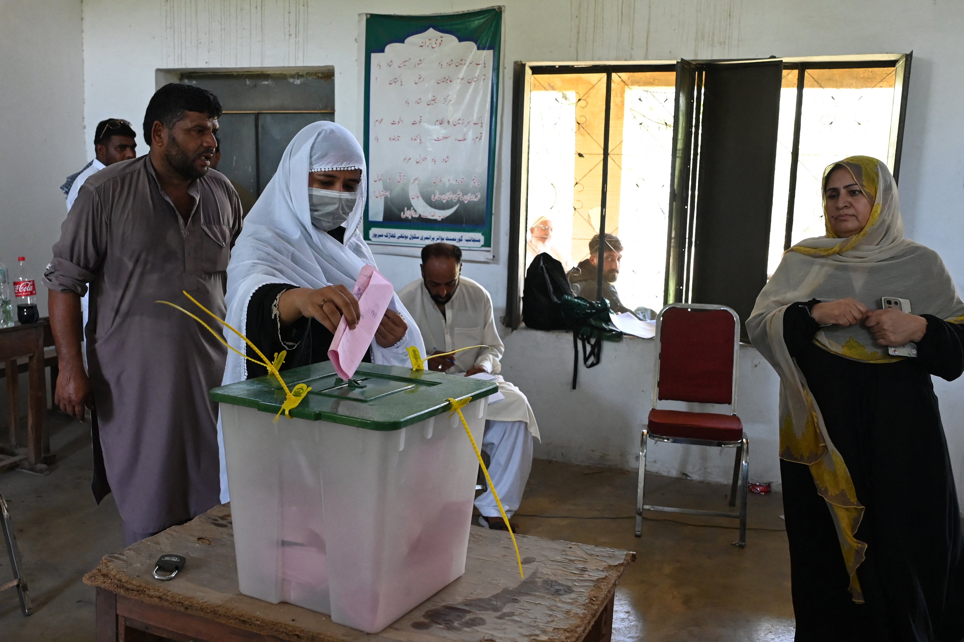 A woman casts her ballot at a polling station during the first phase of regional elections in Pakistan-administered Kashmir's Mirpur on 27 July 2026