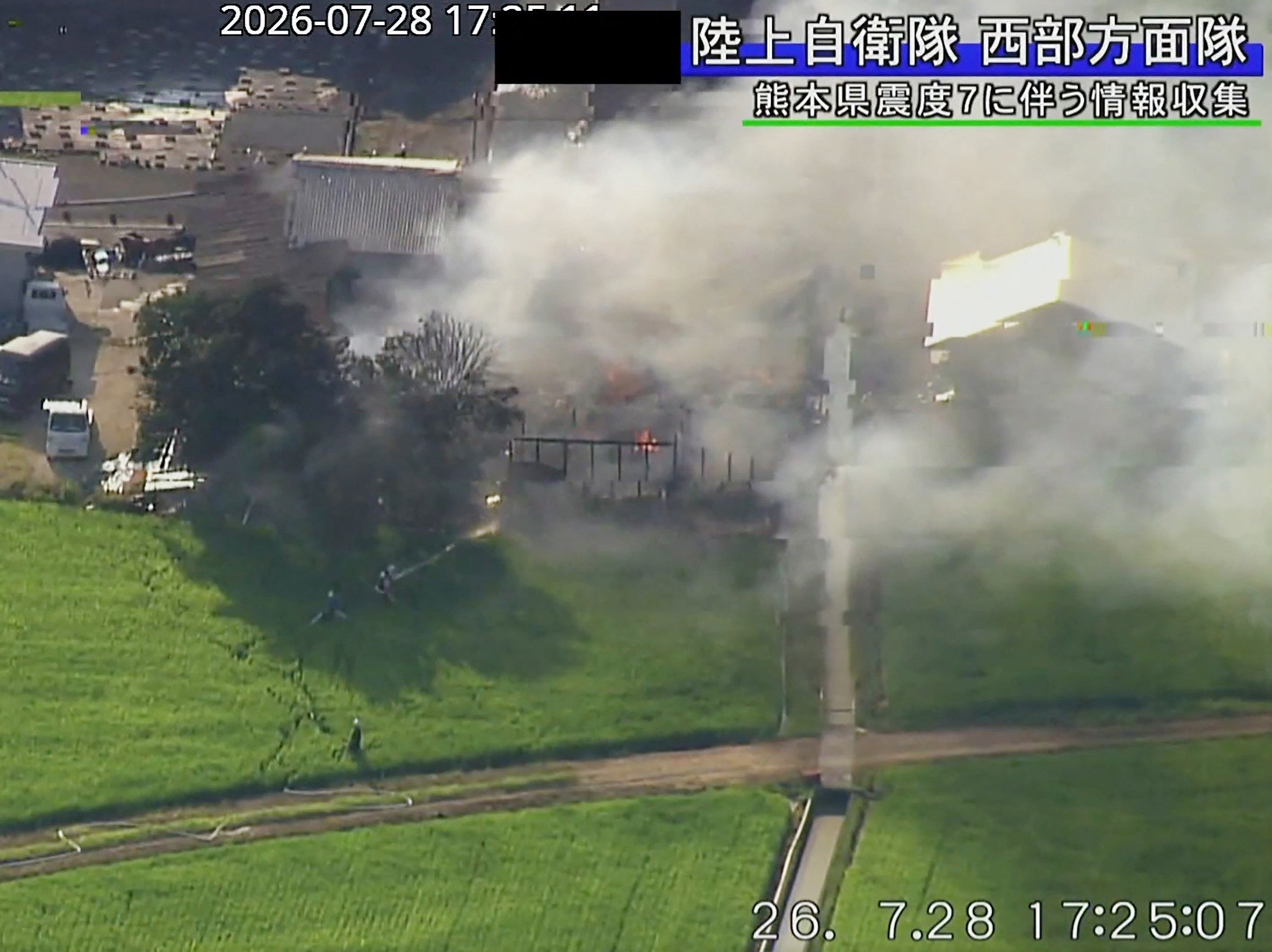 A building with smoke rising from it after an earthquake in Uki City, Kumamoto Prefecture