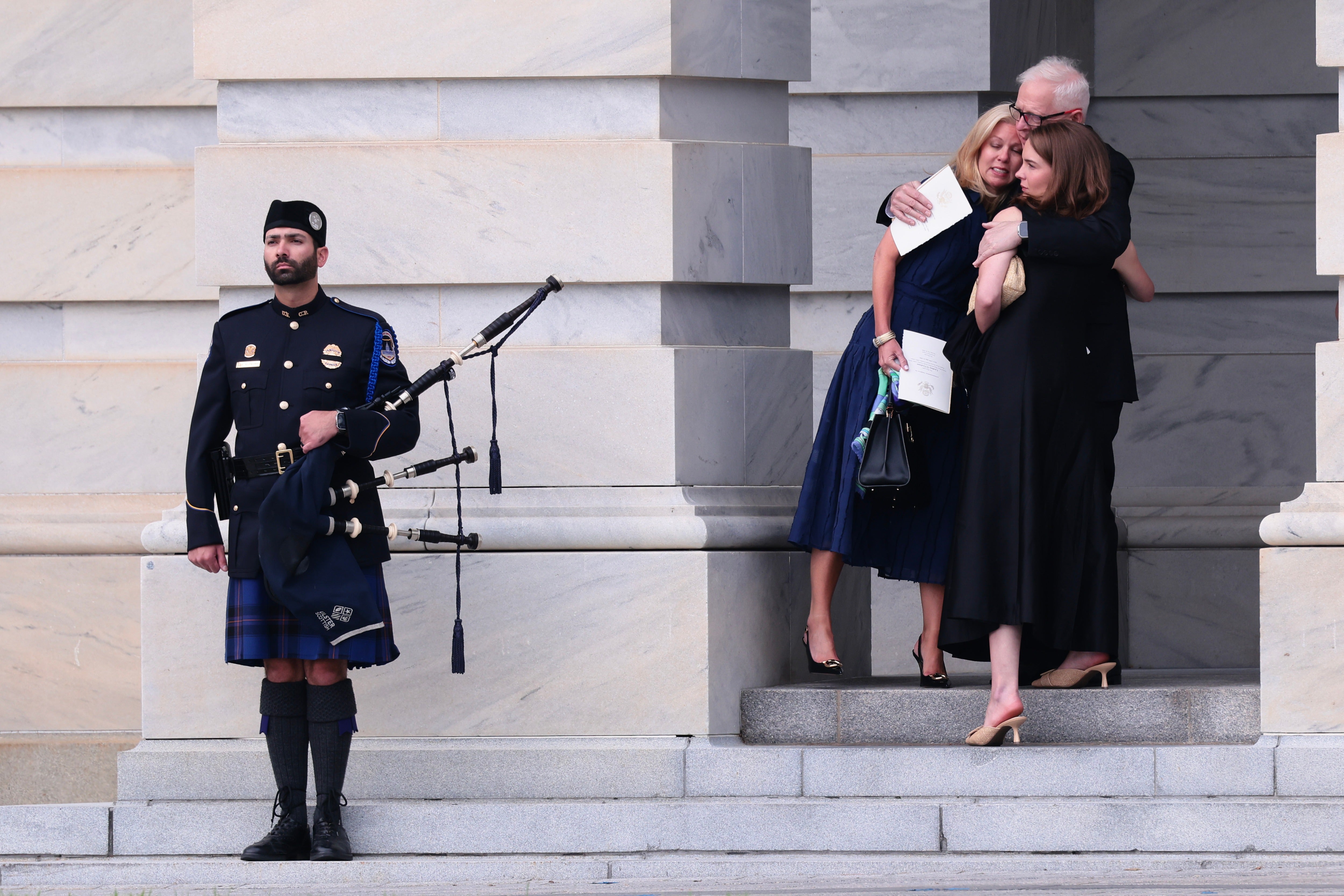 People embrace in front of a bag piper after attending a memorial tribute for the late Sen. Lindsey Graham (Getty Images)