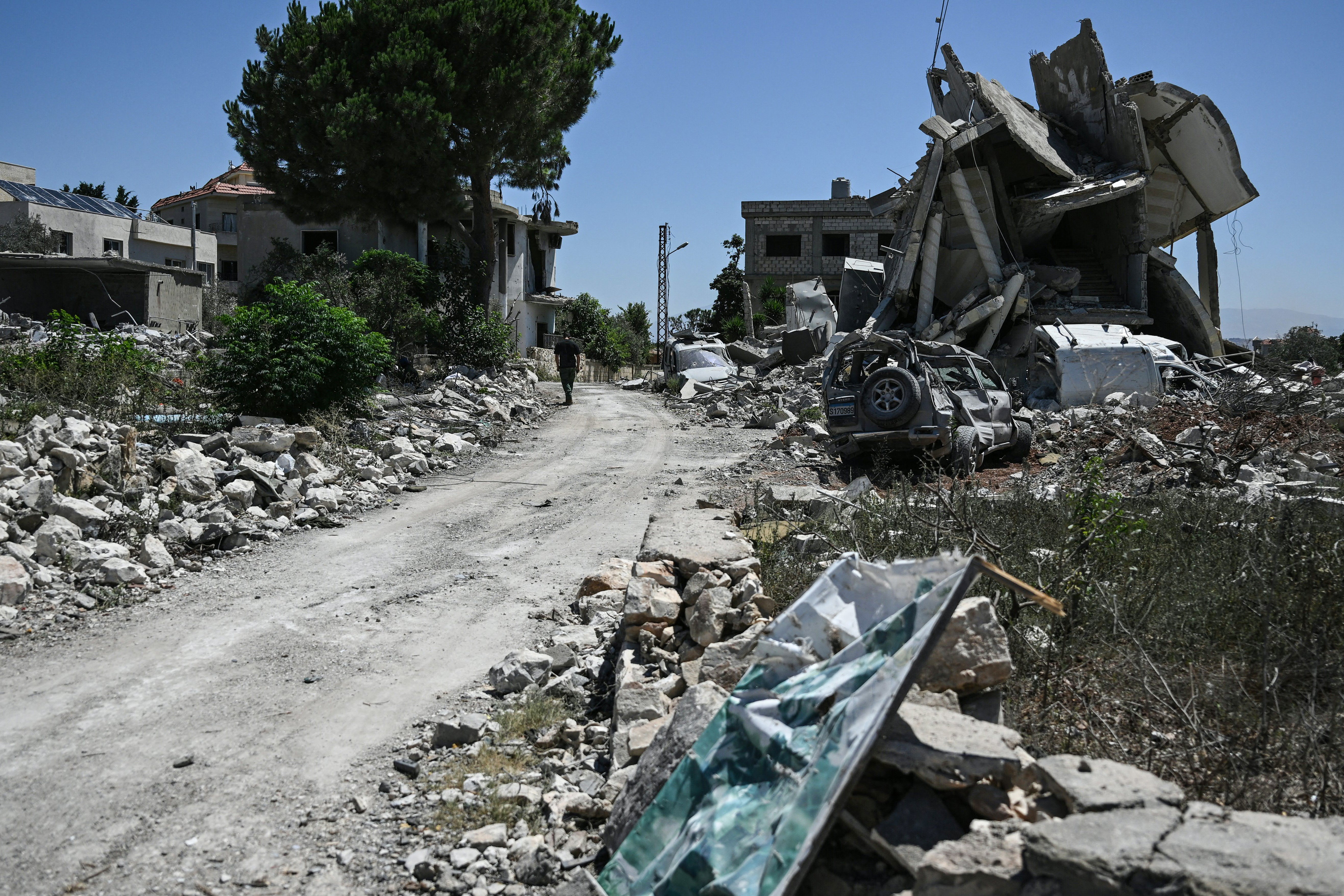 A man walks past damaged buildings in Zawtar al-Gharbiya on July 28, 2026, as residents check on their homes after the Lebanese army deployed to the southern village last week as part of a framework deal reached with Israel. (AFP/Getty)