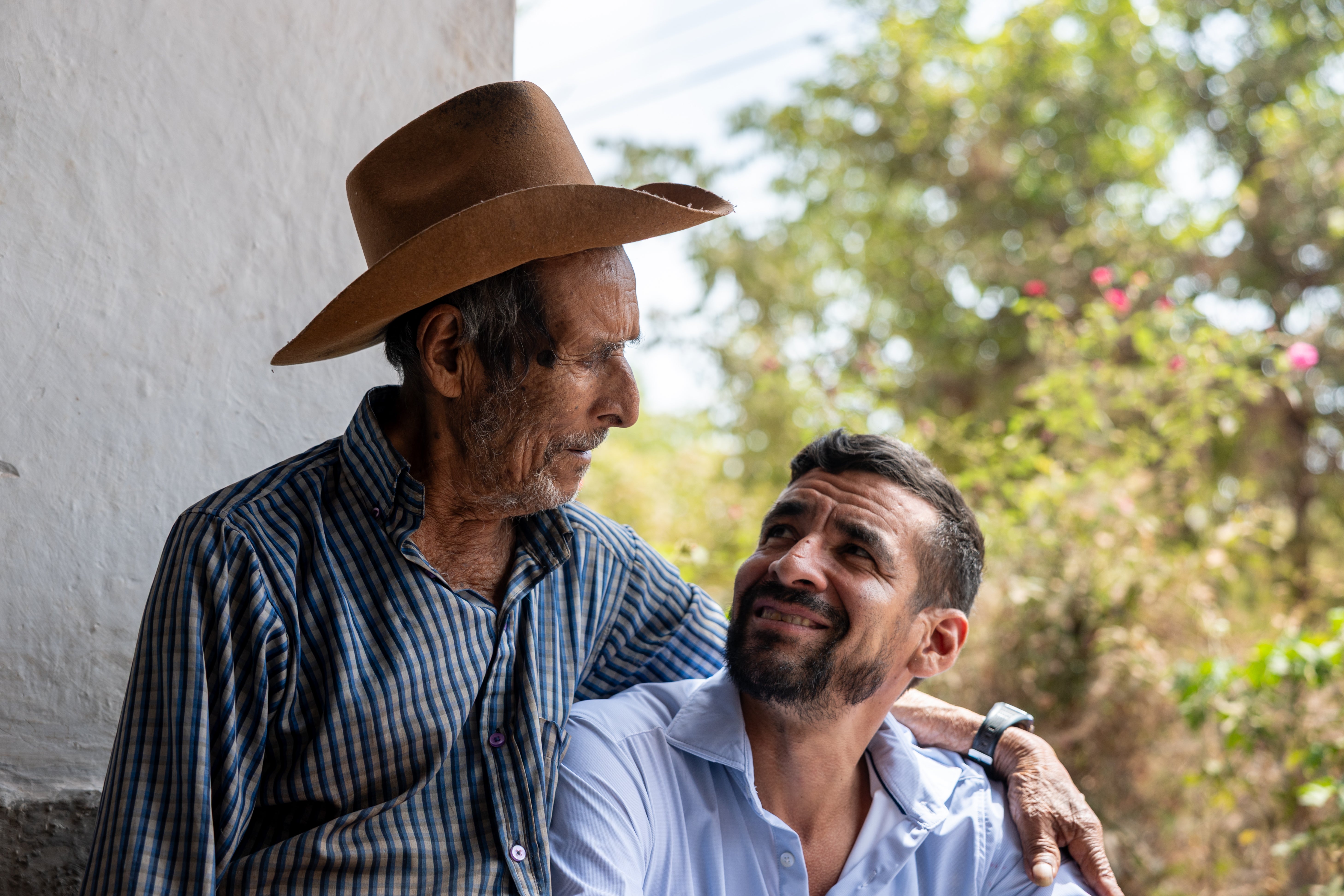 Marvin Suazo, right, visits his 100-year-old grandfather, Esteban Suazo, in El Junco, Salvador, one day after self-deporting from the US on May 26, 2026