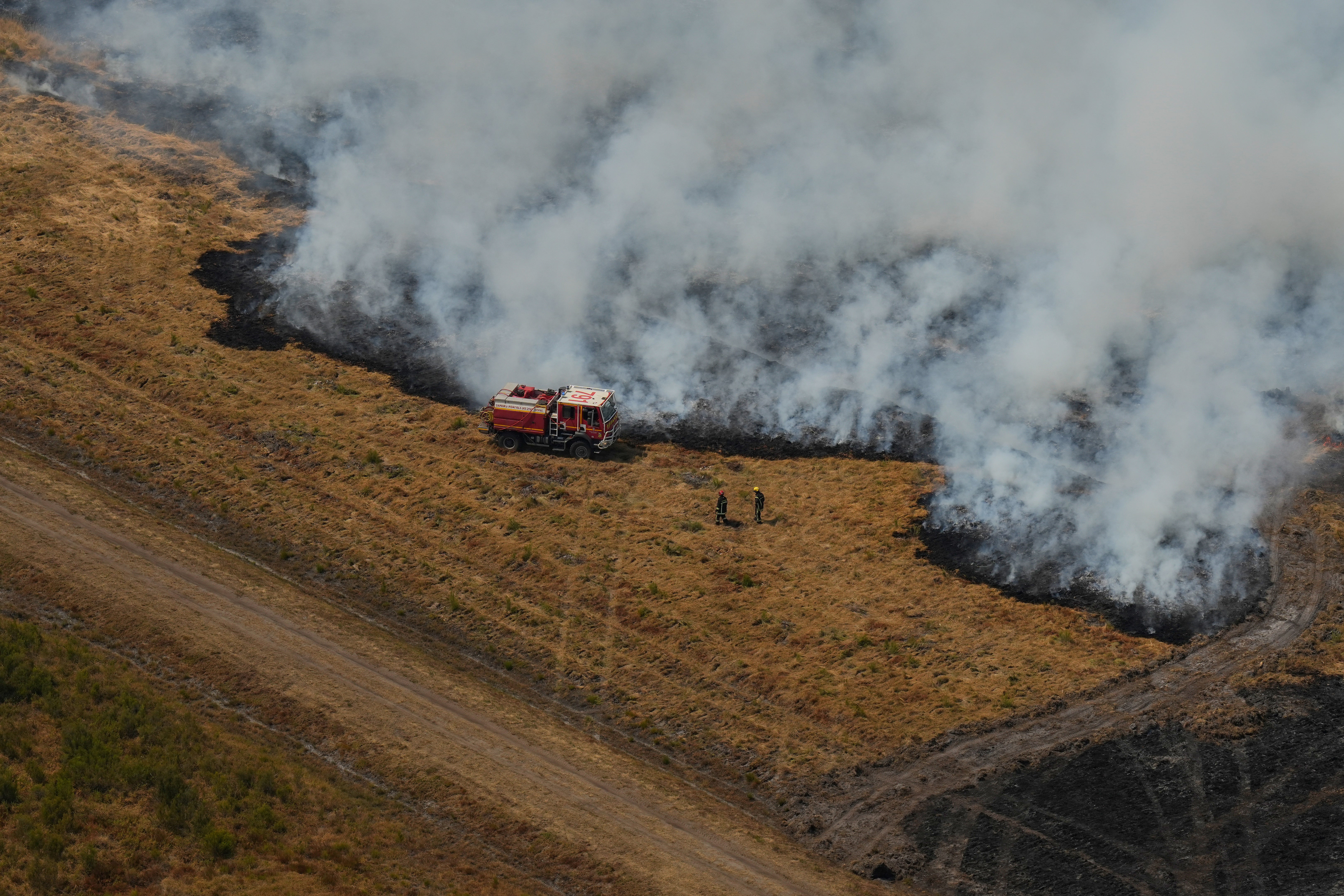 Firefighters try to suppress a fire burning through a field near Ares, southwestern France (AFP/Getty)