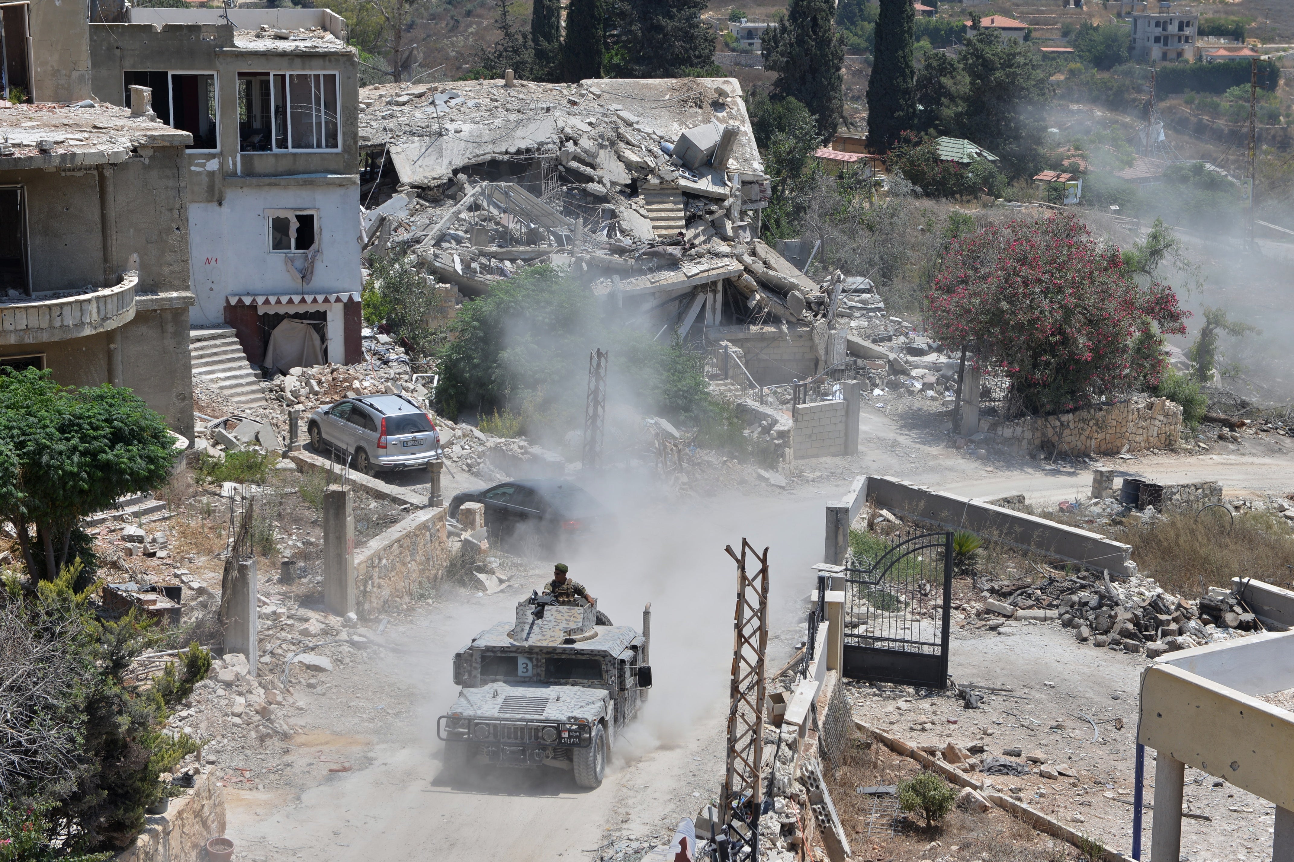 A Lebanese military vehicle drives past homes damaged during the war in the southern village of Zawtar al-Gharbieh, Lebanon