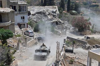 A Lebanese military vehicle drives past homes damaged during the war in the southern village of Zawtar al-Gharbieh, Lebanon