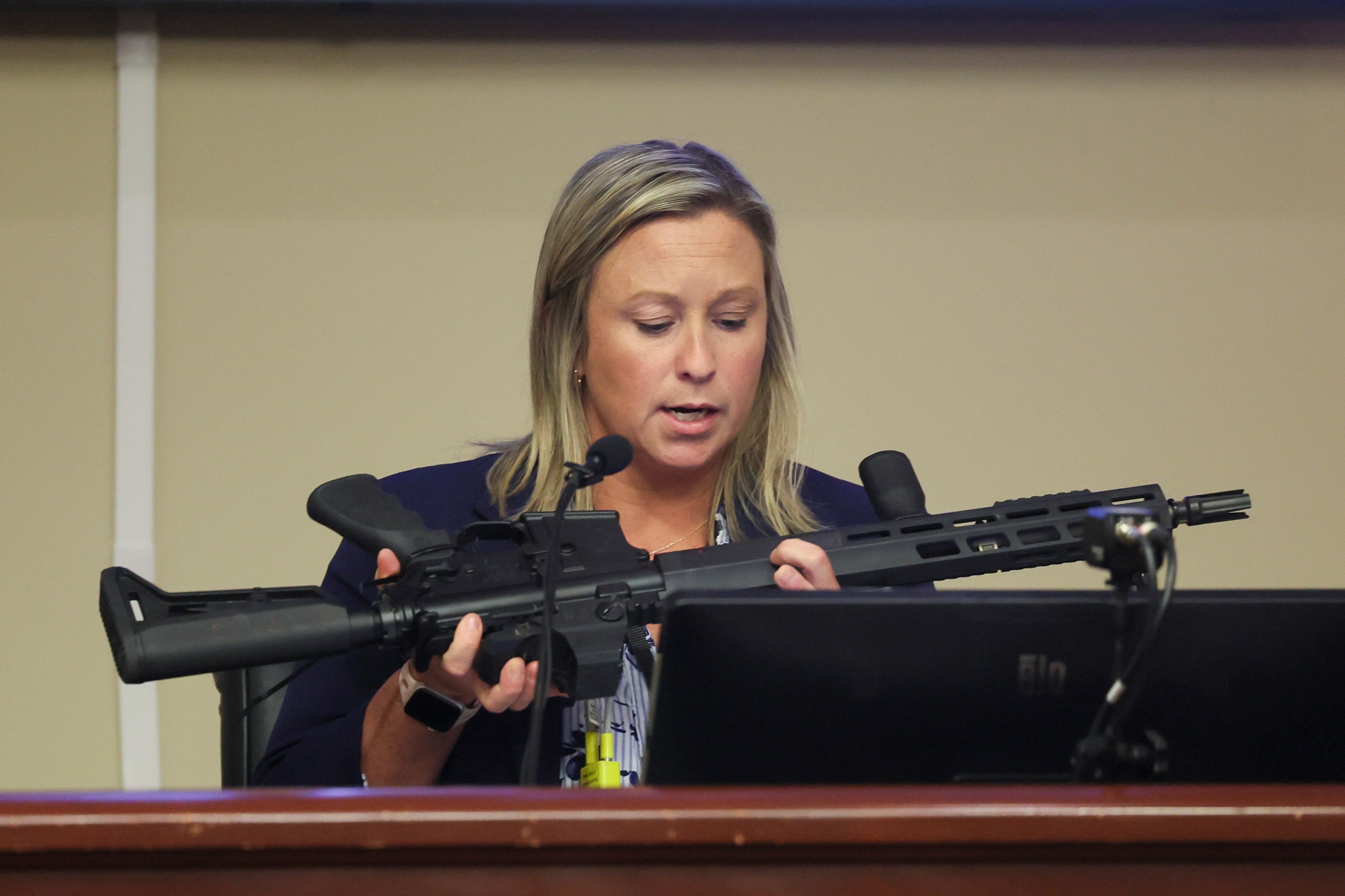 An investigator with the Barrow County District Attorney's office looks over the assault rifle that Colt Gray used in the Apalachee High School shooting