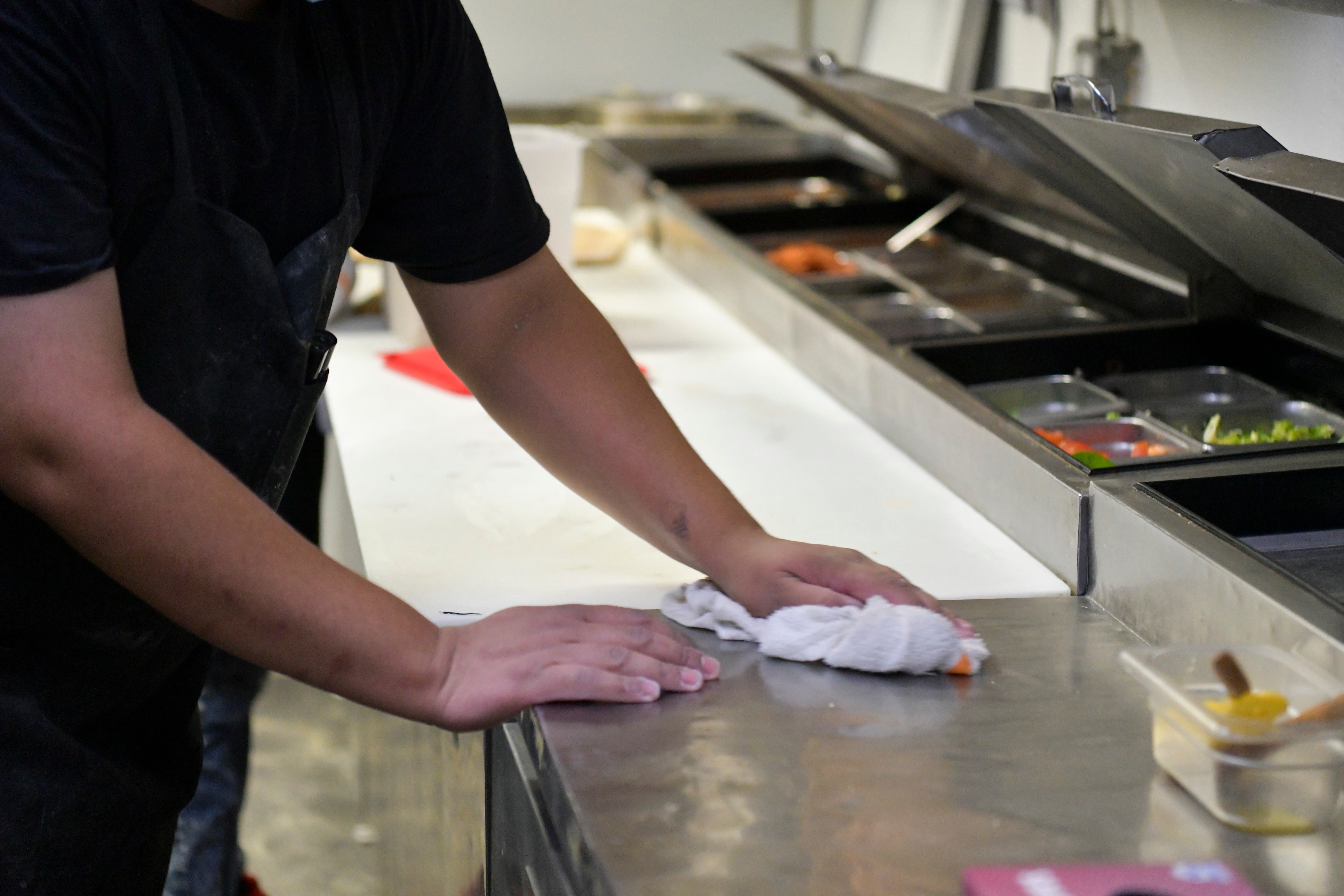 An employee cleans the food preparation area (Getty Images)
