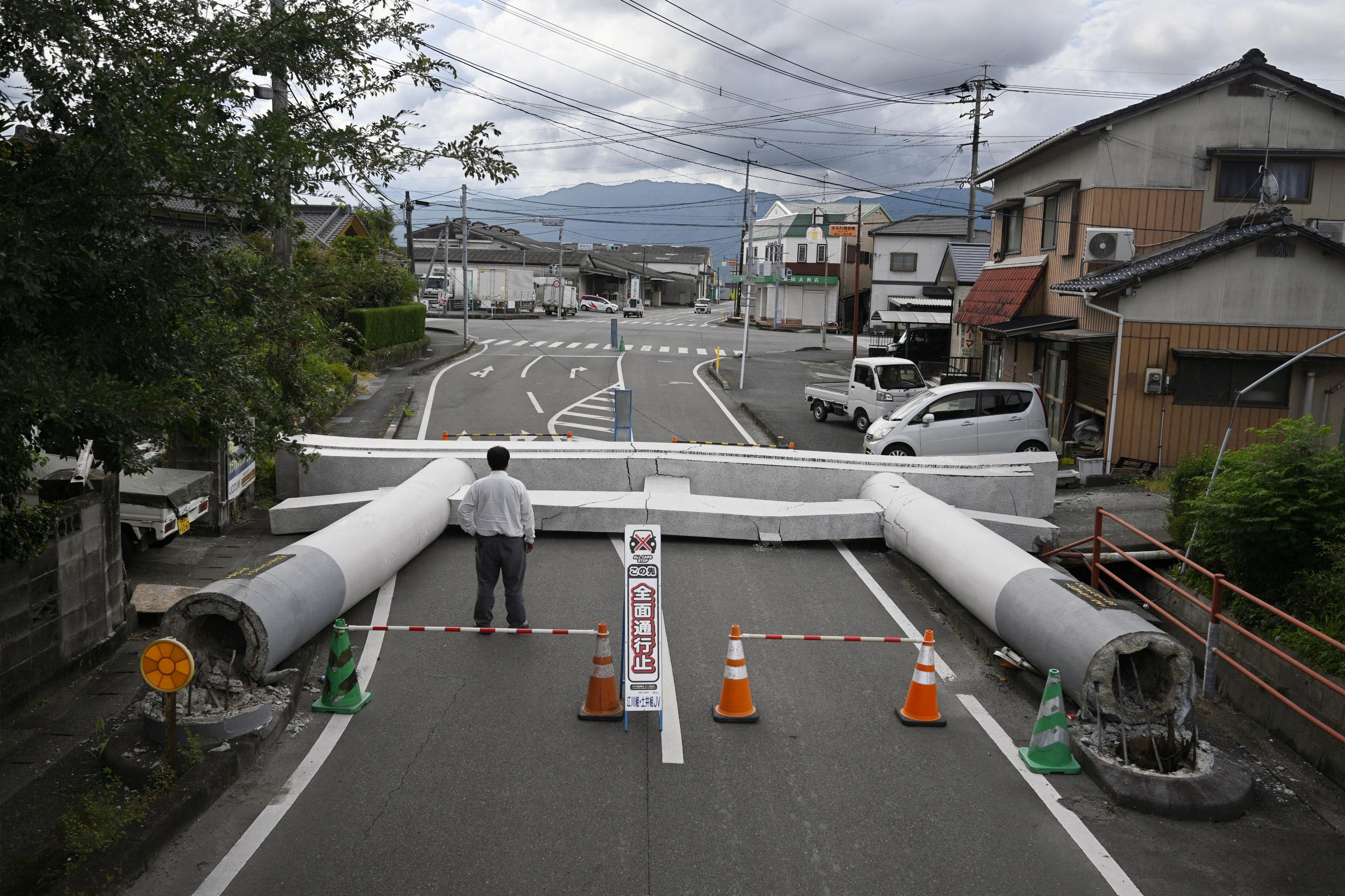 A man looks at a Torii gate that collapsed after an earthquake (Reuters)