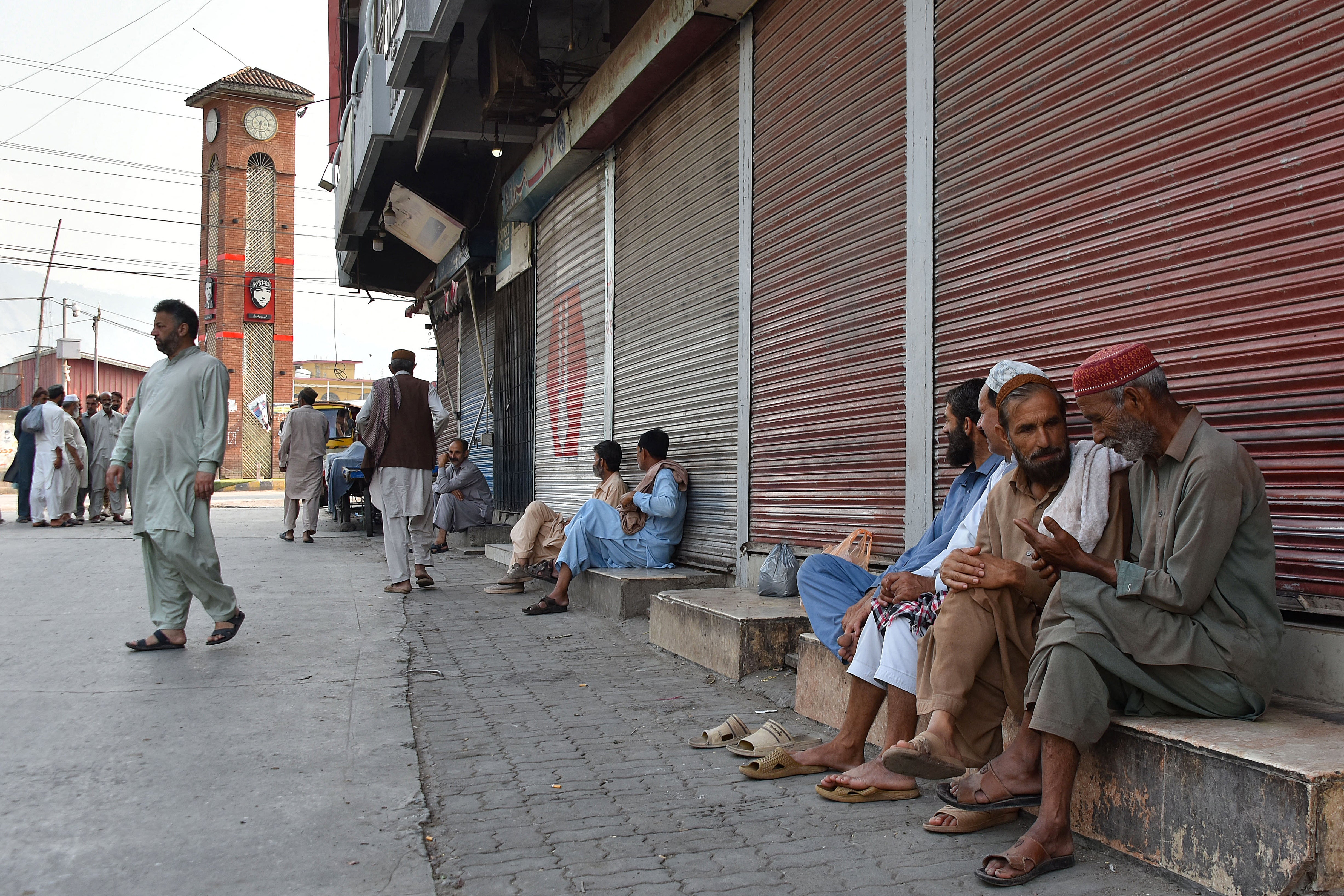 People gather near closed shops at a marketplace in Muzaffarabad, the capital of Pakistan-administered Kashmir on 16 June 2026 amid protests called by the Joint Awami Action Committee (JAAC)