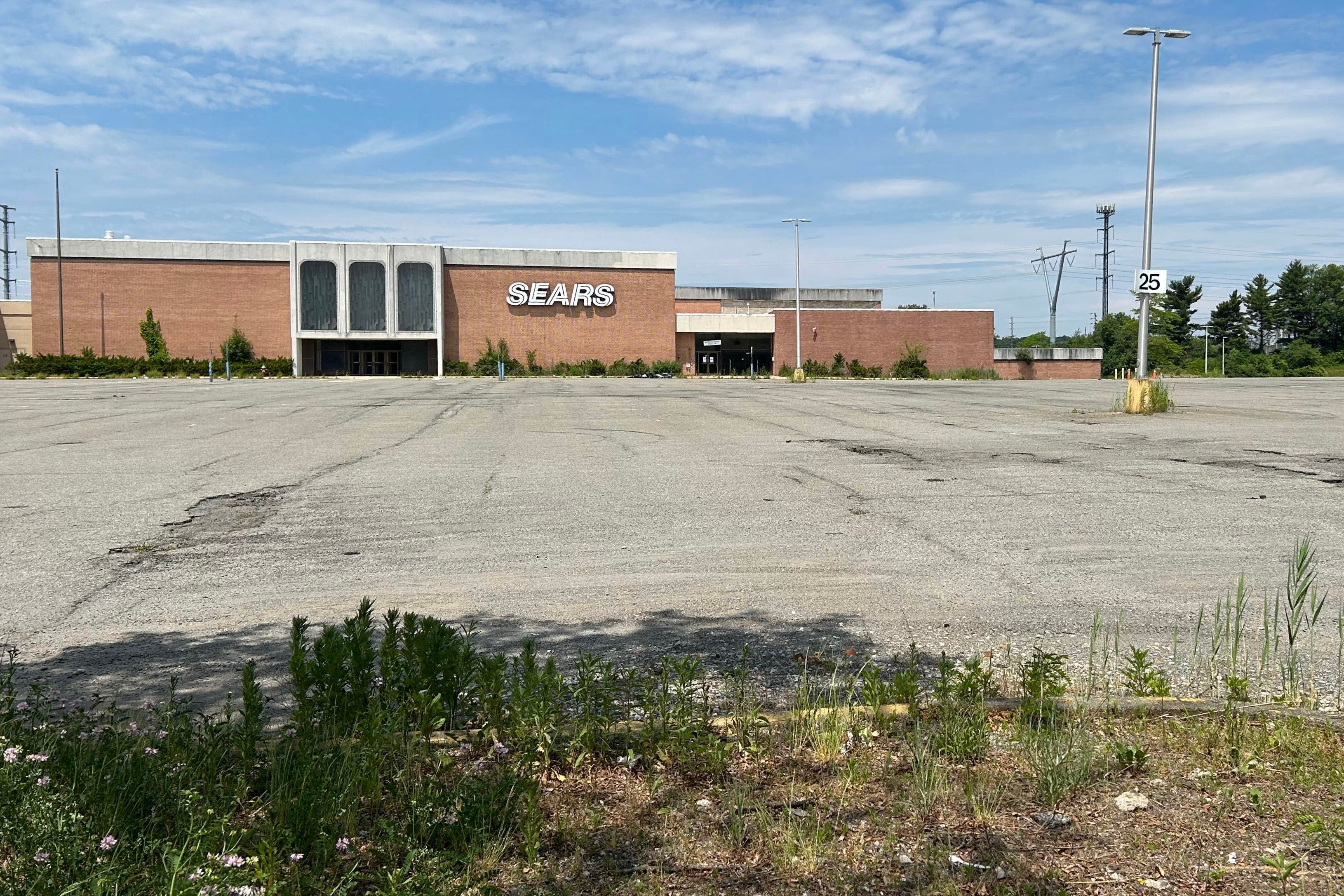 Today, the site presents a desolate picture of crumbling buildings, overgrown grass, potholes, and discarded tires