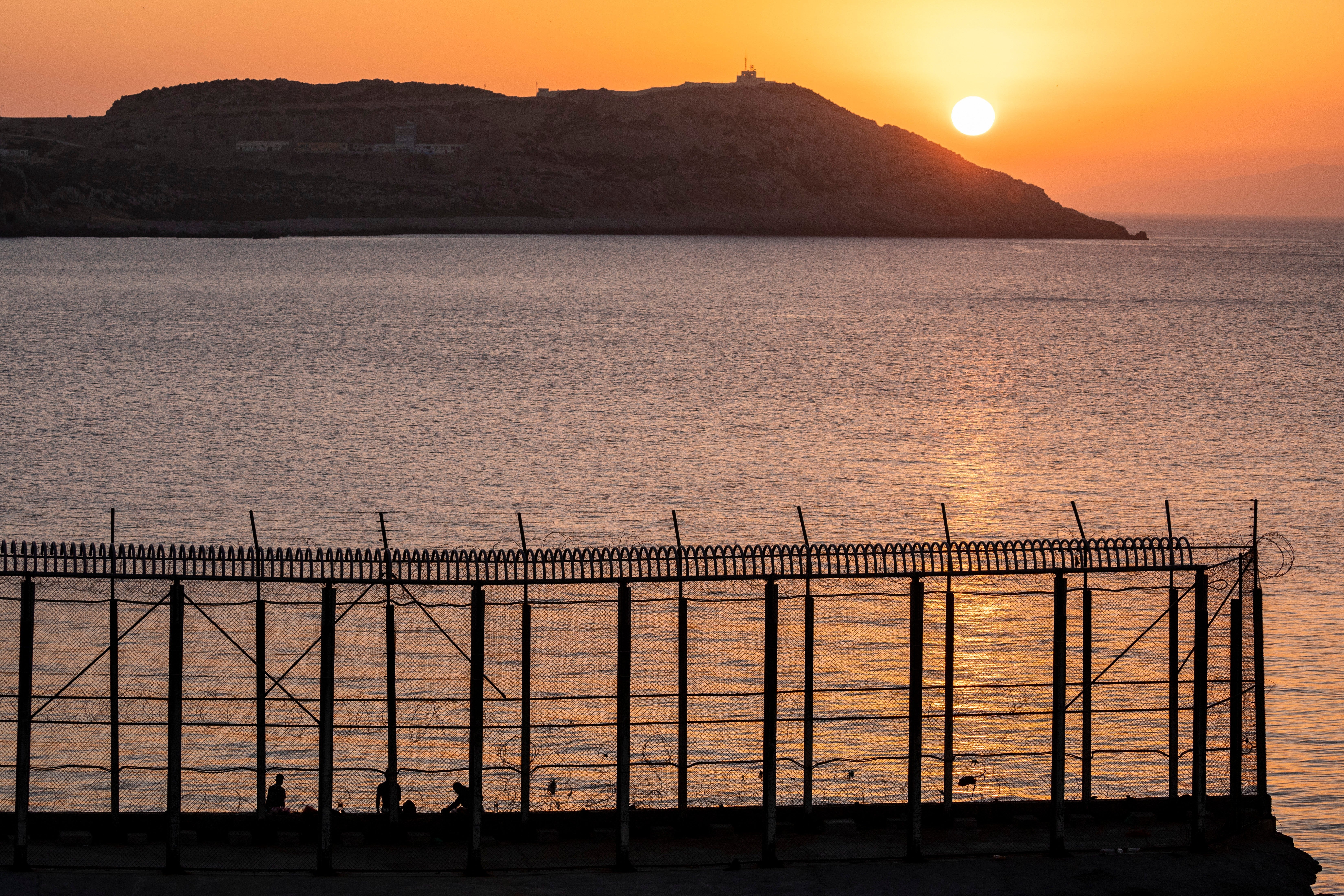 Moroccan men fish on the Moroccan side of the border with Spain, as seen from the district of Benzu in the Spanish enclave of Ceuta, June 3, 2021. (AP Photo/Bernat Armangue, File)
