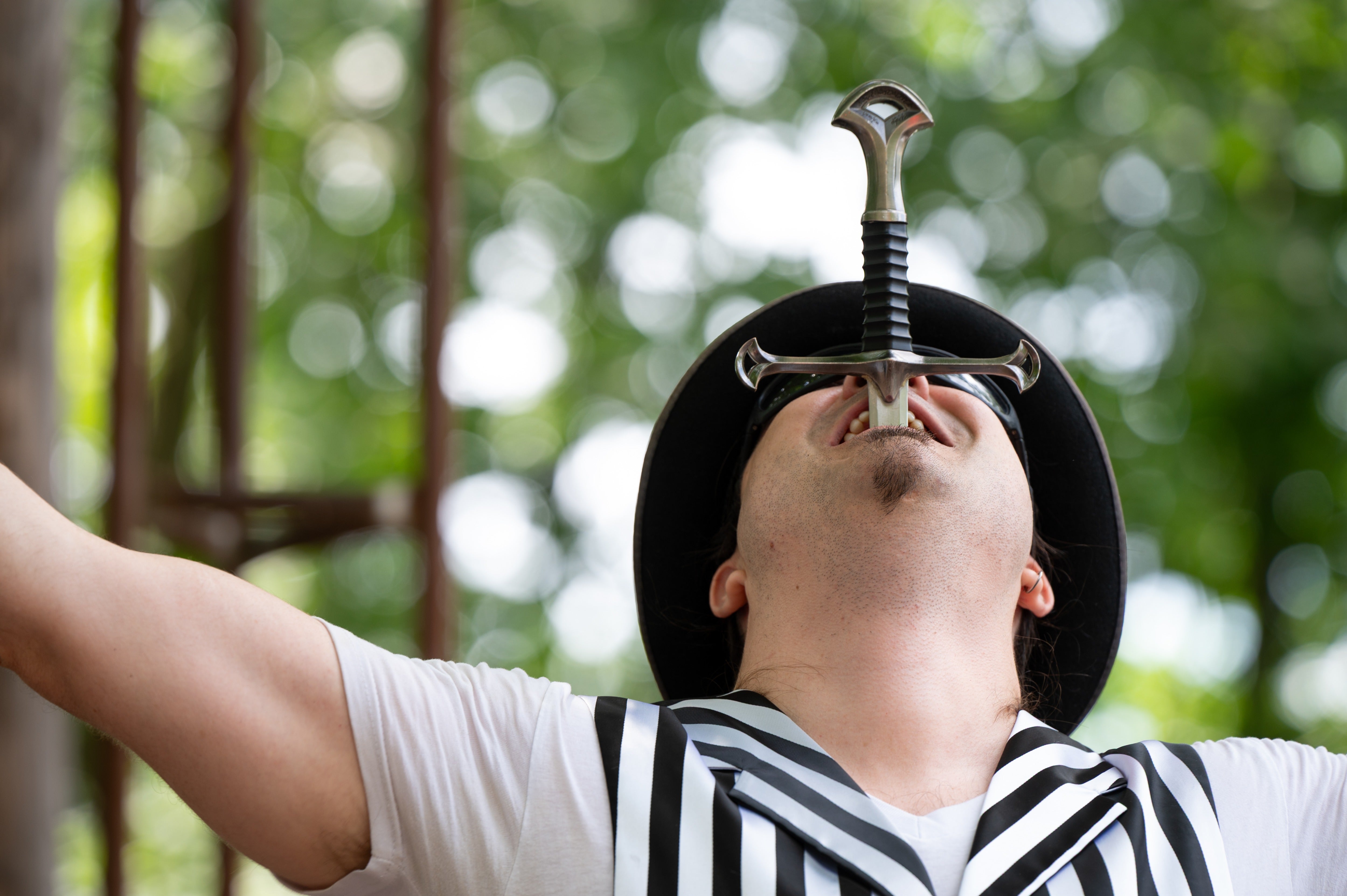 Nathan Wakefield, the new owner of Mystery Hill, swallows a sword during a pop-up carnival at the roadside attraction Onsted, Mich., on Saturday, July 18, 2026