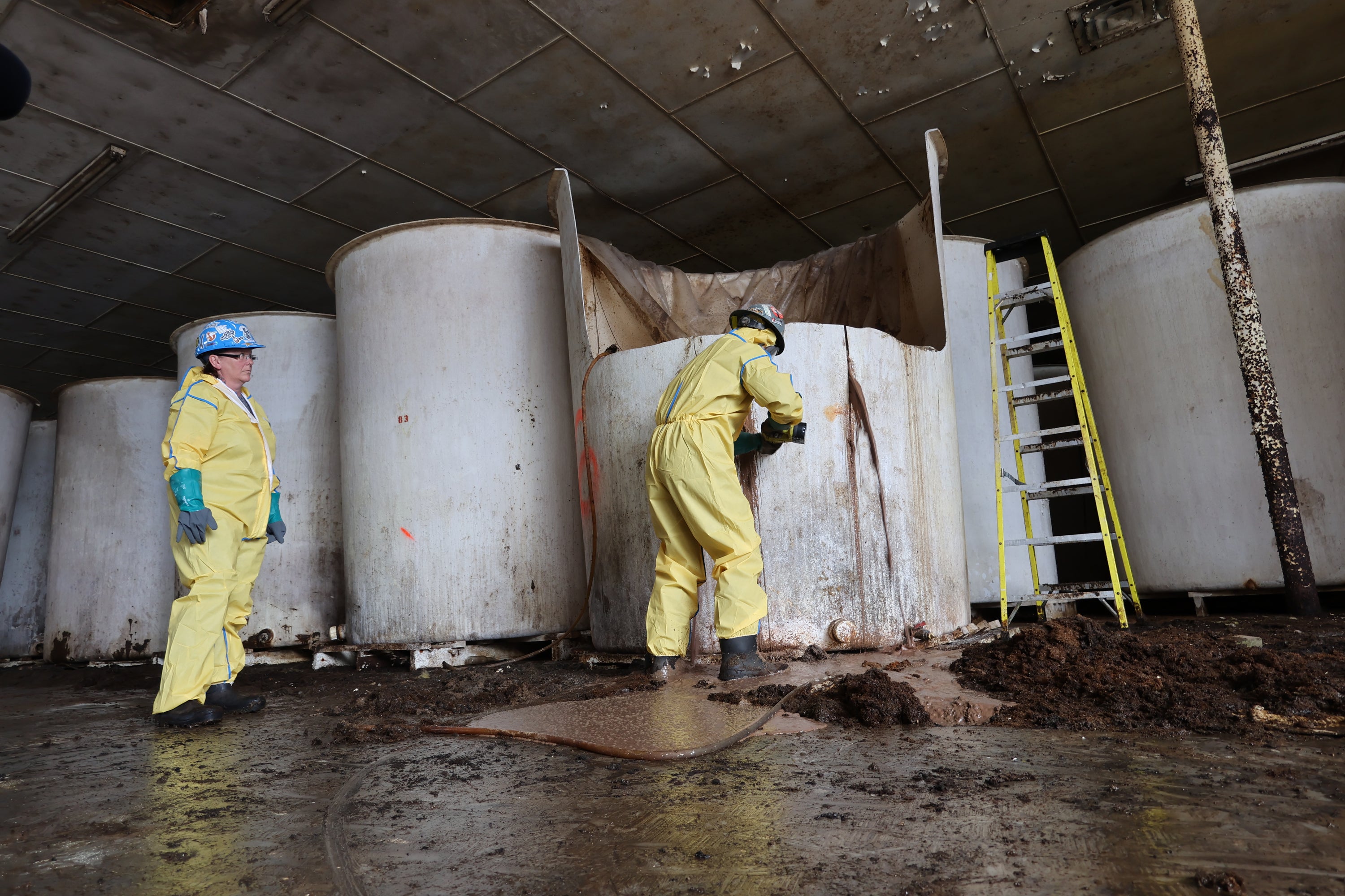 Sludge pours out of a vat of fermenting fish sauce in an abandoned fish sauce factory in St. Mary's, N.L., on Tuesday July 28